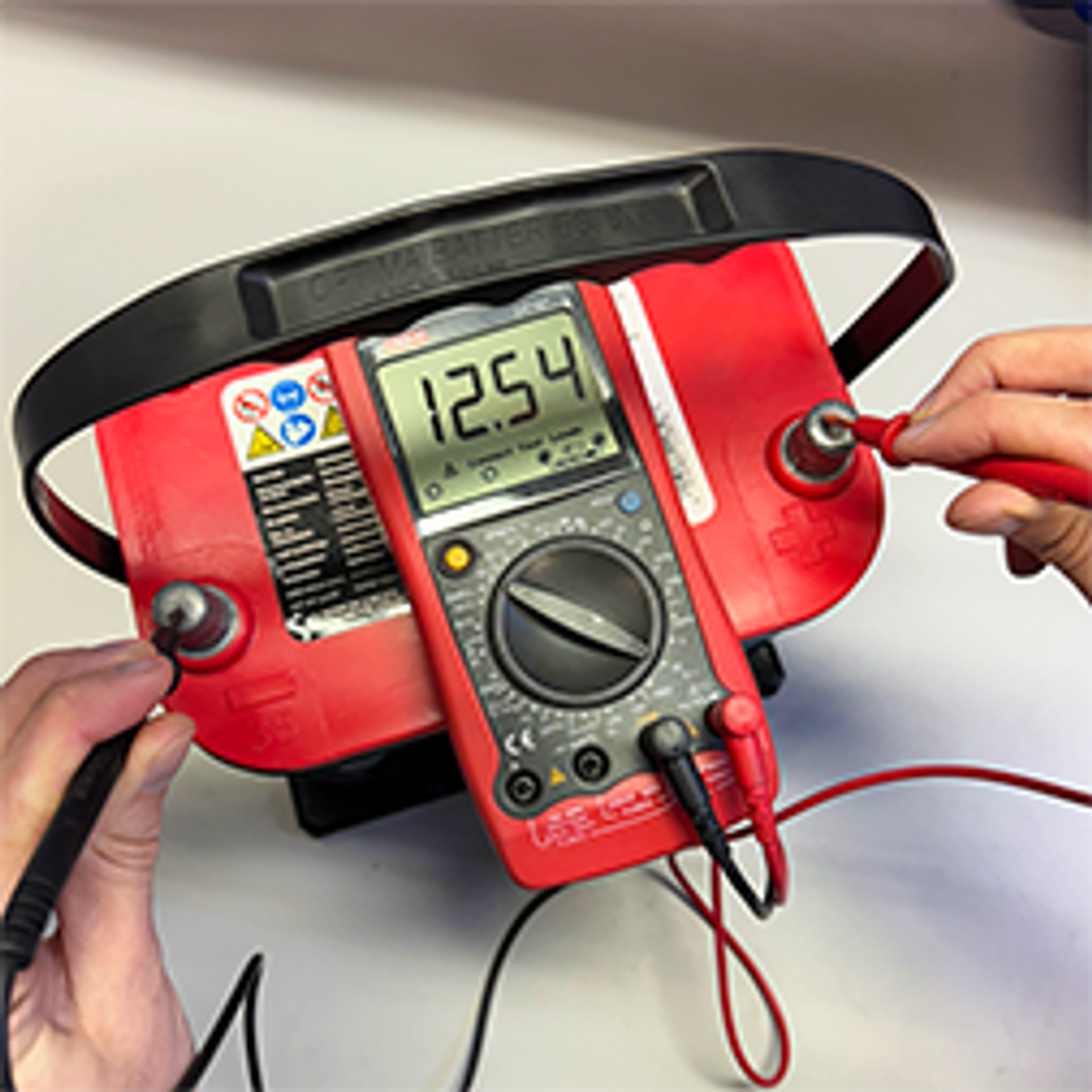 Multimeter som mäter spänningen över ett batteris poler