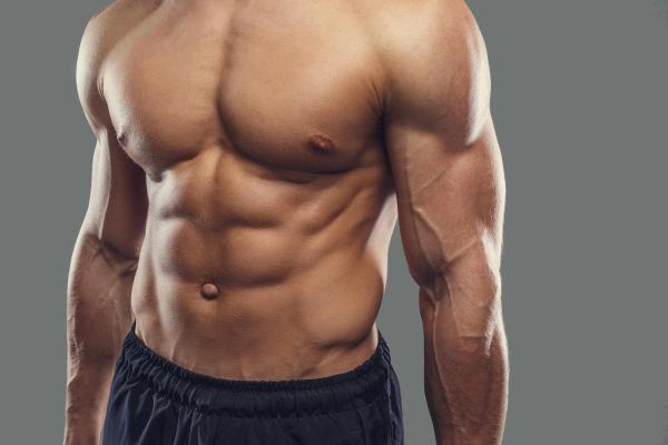 Close up of shirtless sportsman holding injection 