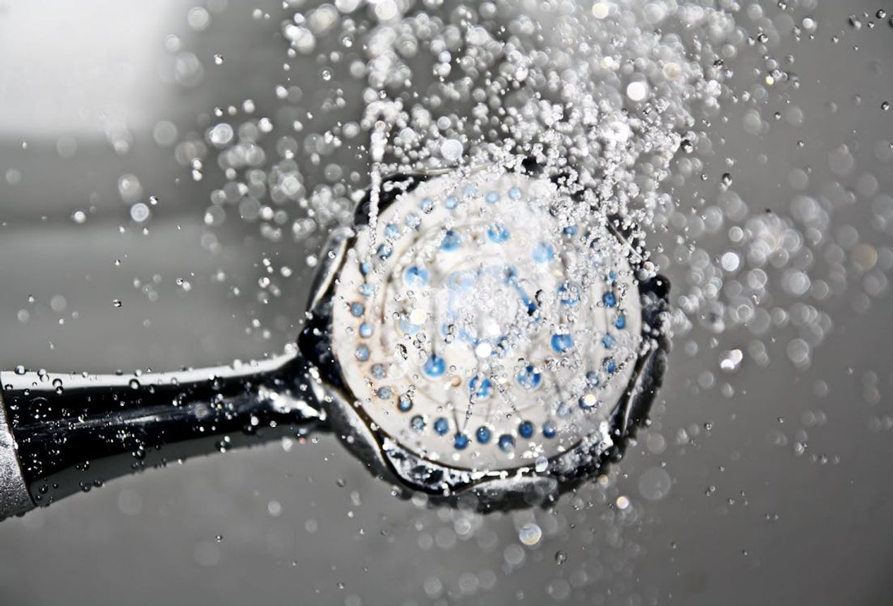 water flowing from black shower head