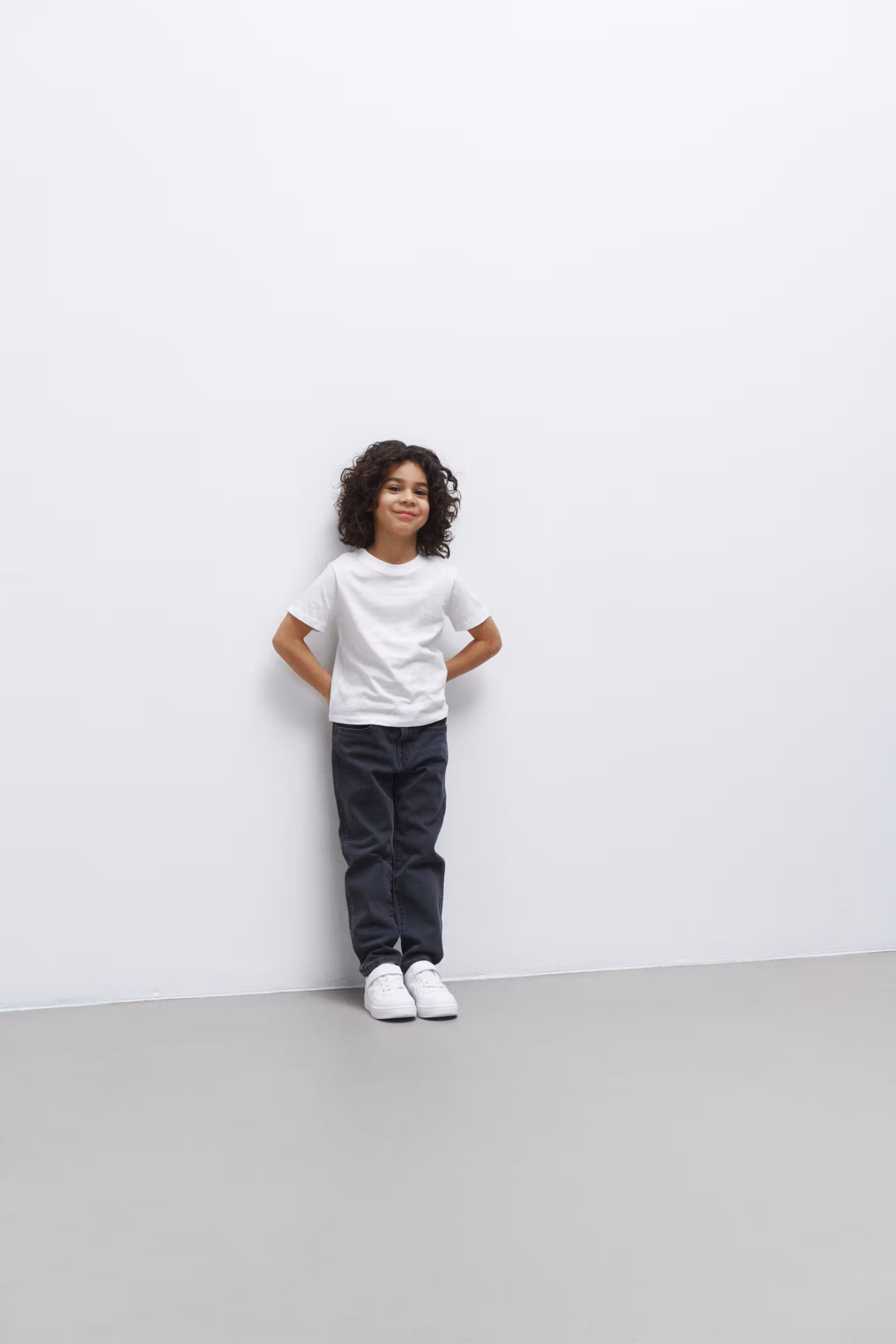 A kid model showing a white kid tee