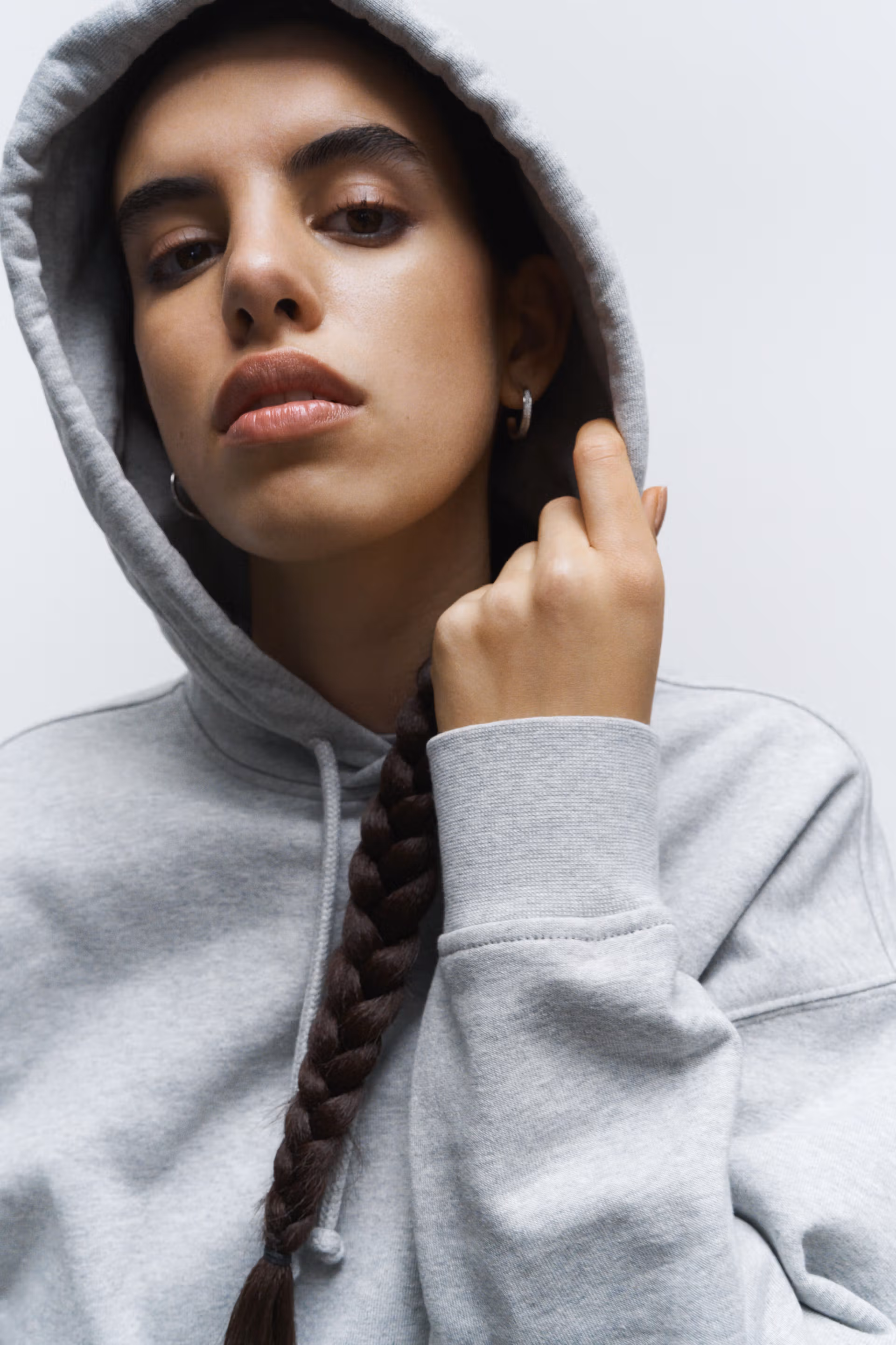 A female model wearing a grey Creator Studio heavy weight hoodie