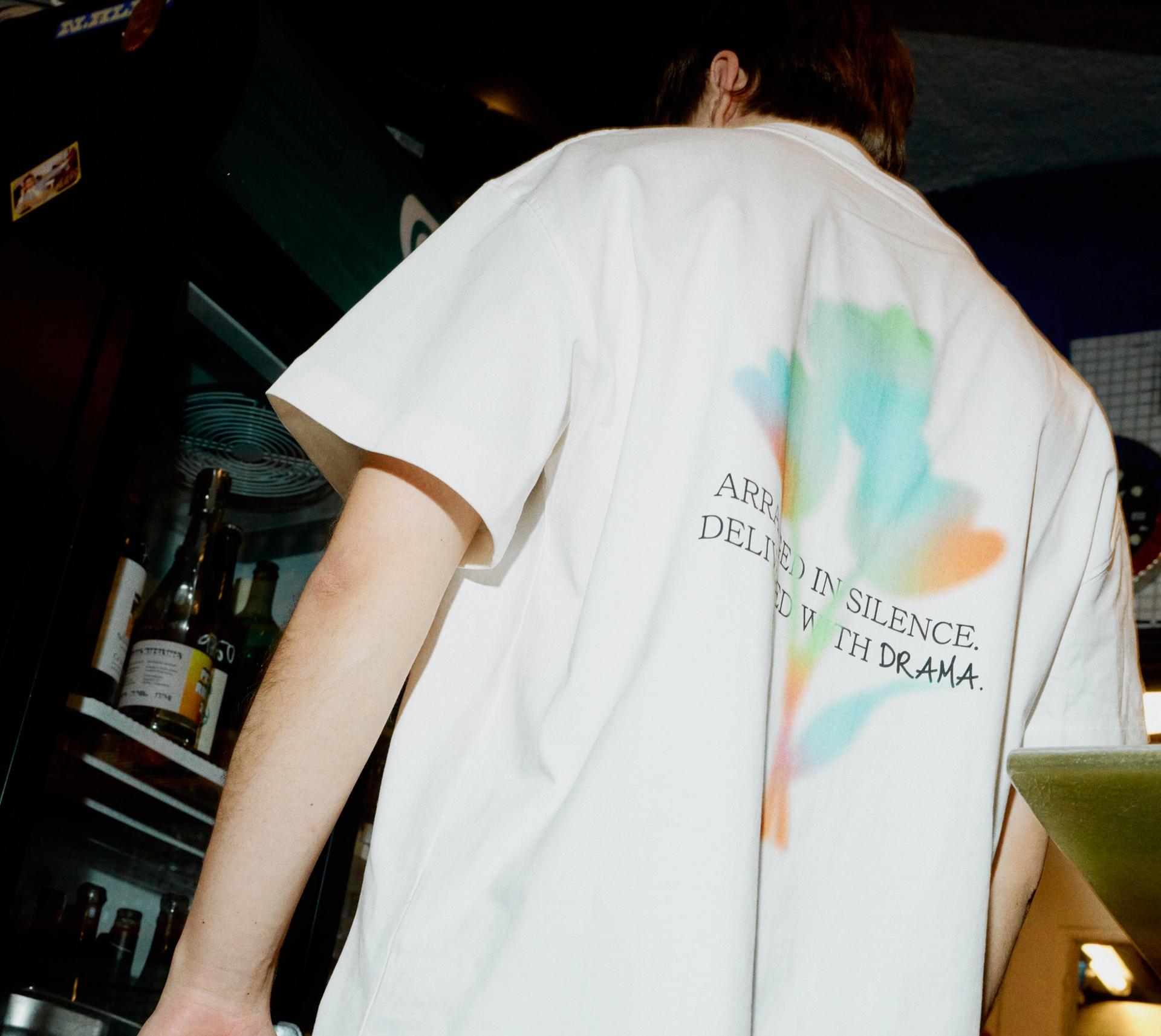 A male model wearing a white Creator Studio custom printed tee