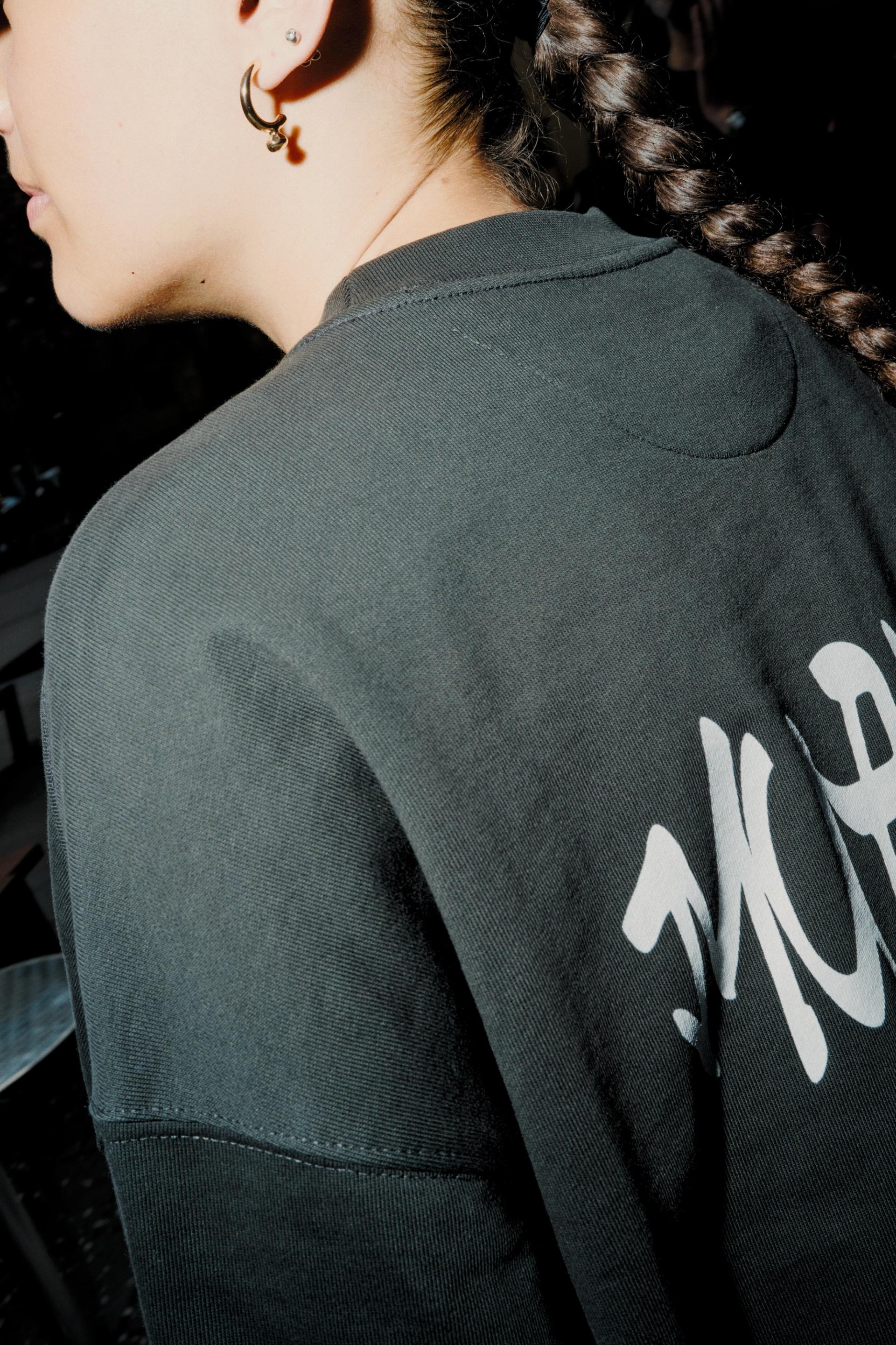 A female model wearing a black hoodie produced and made by Creator Studio