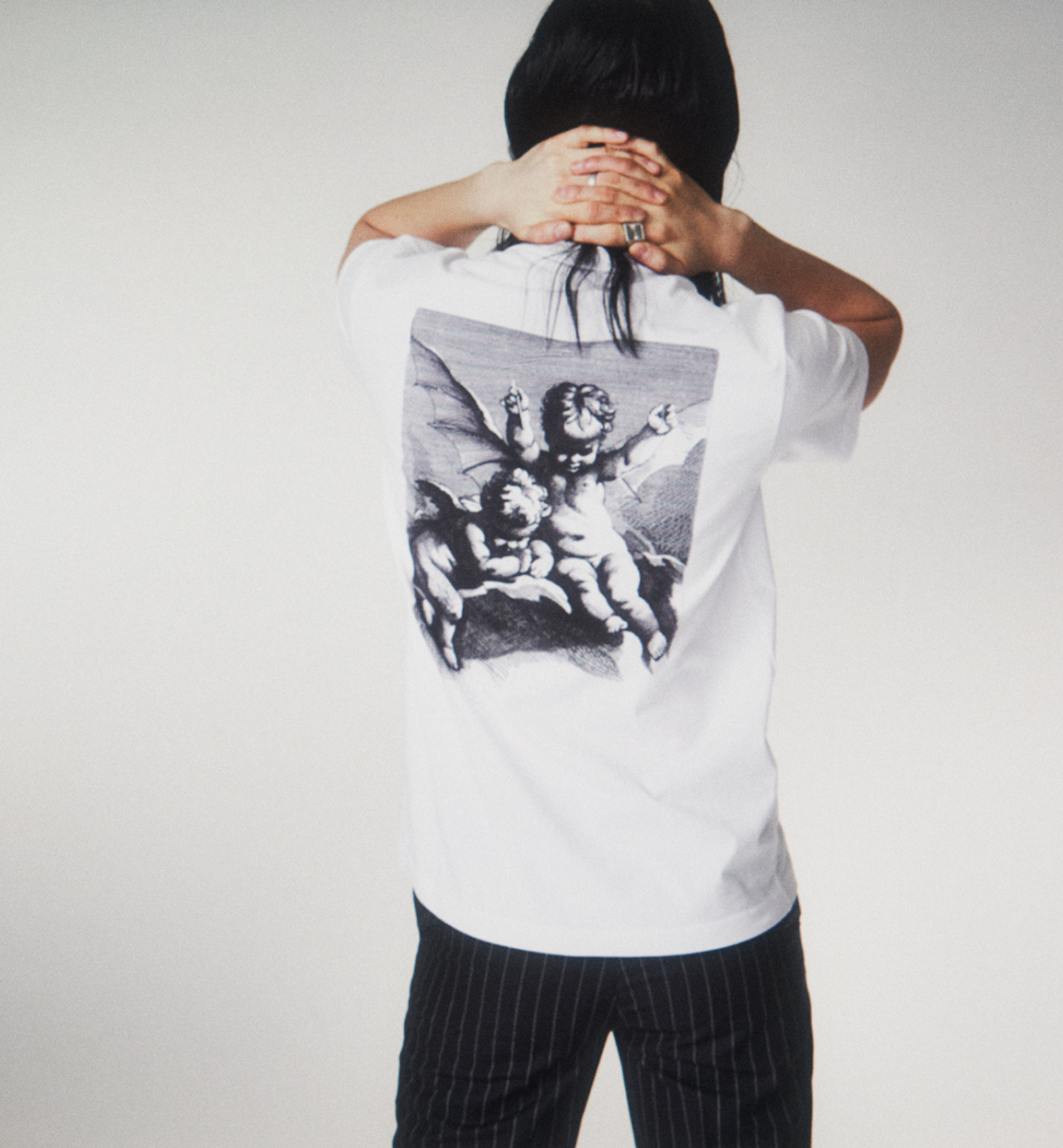 A model wearing a white T-shirt with Creator Studio print