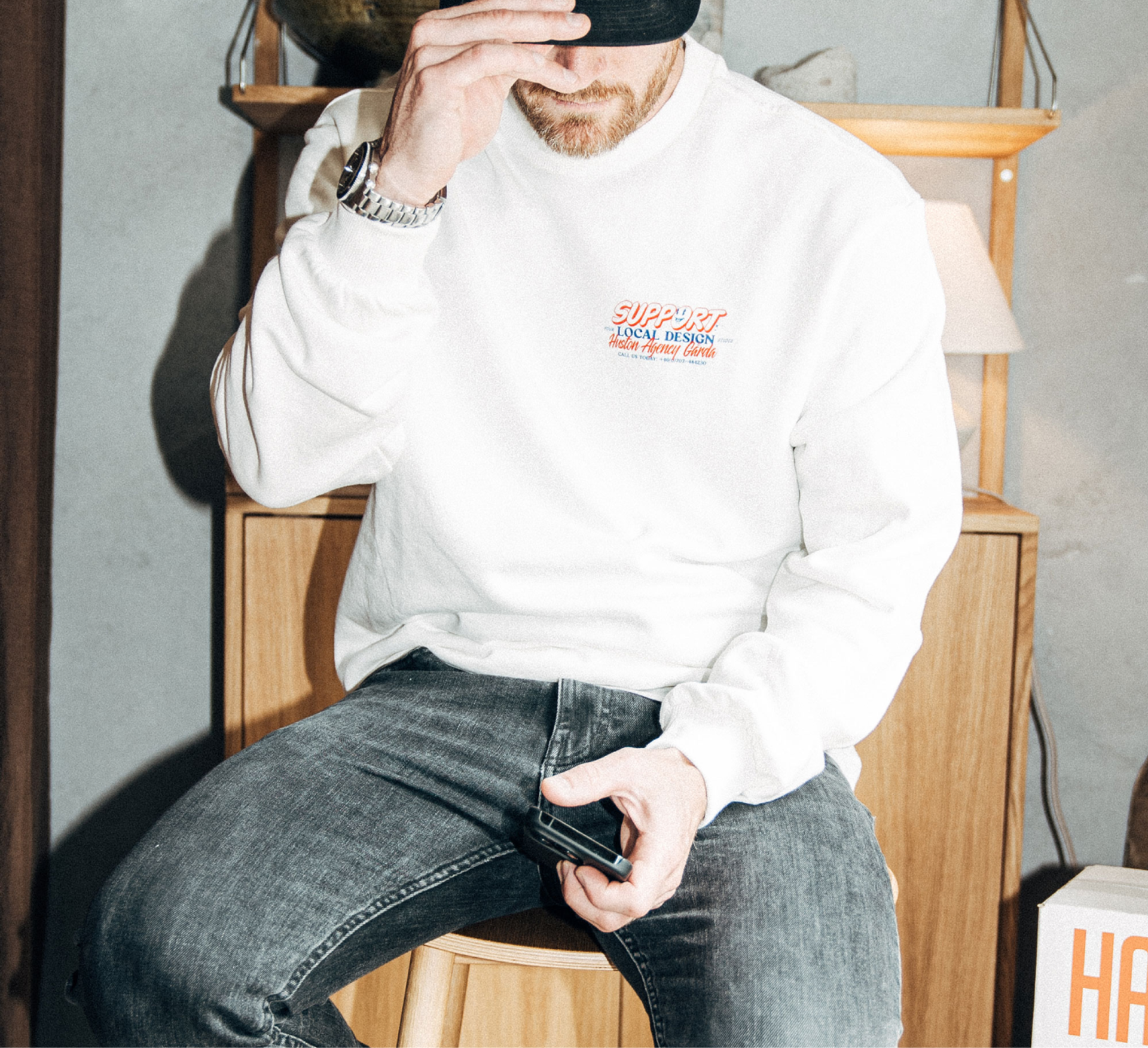 A man wears a custom printed Creator Studio sweatshirt