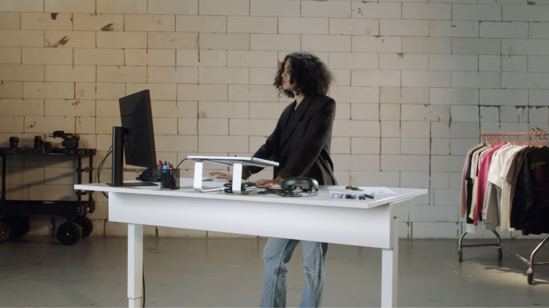 A female designer working on her computer to design custom merch with Creator Studio