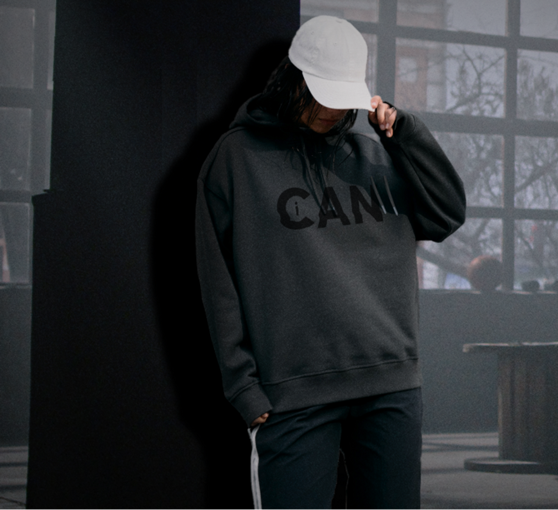 A girl in a cap wears a Creator Studio hoodie