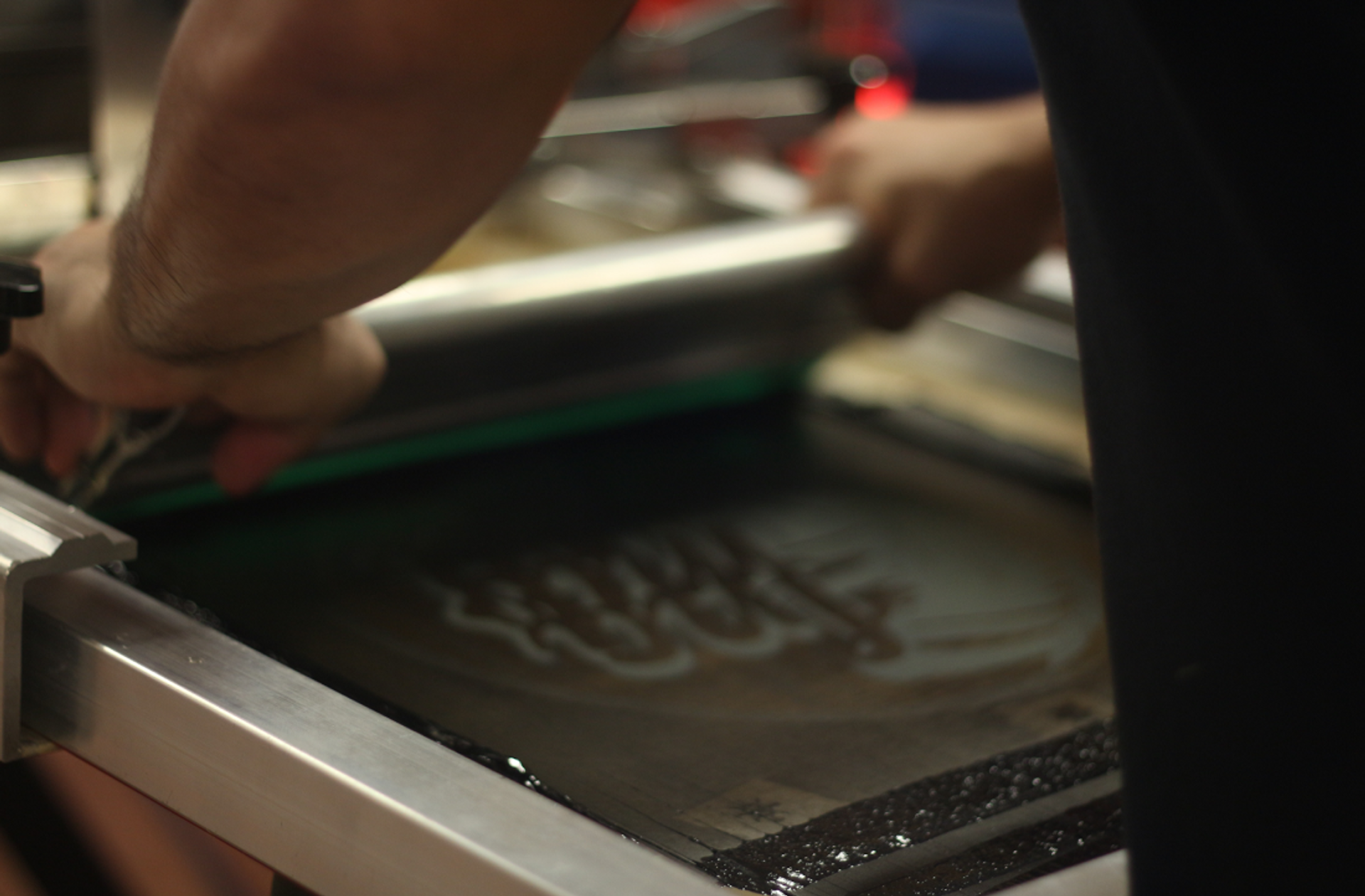 A creator's artwork is being screen printed onto a True Blanks garment