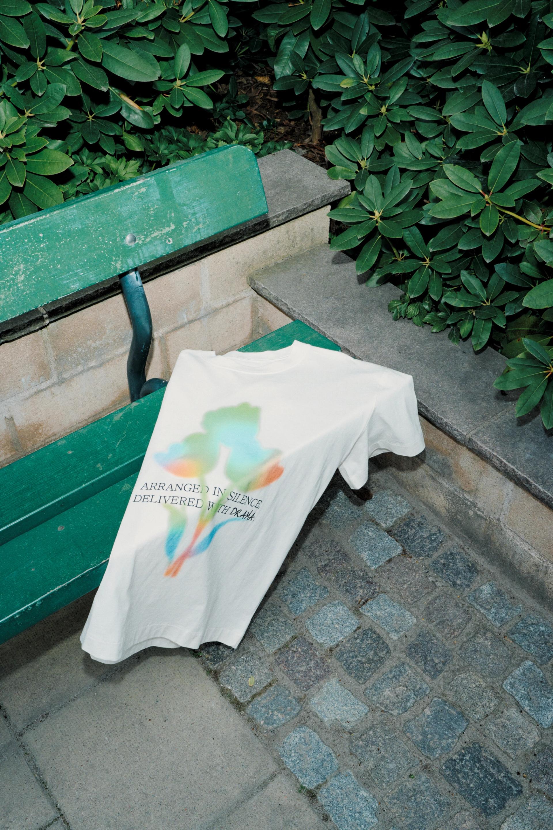 A white tee custom printed with digital print technique on a green chair