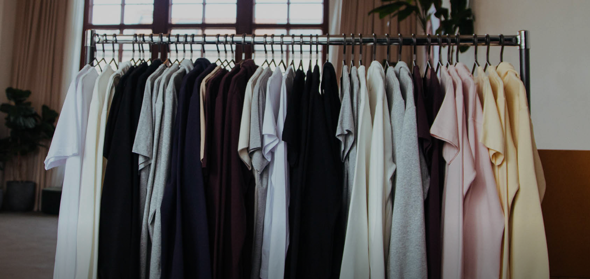 A collection of True Blanks garments hanging on a clothes rack
