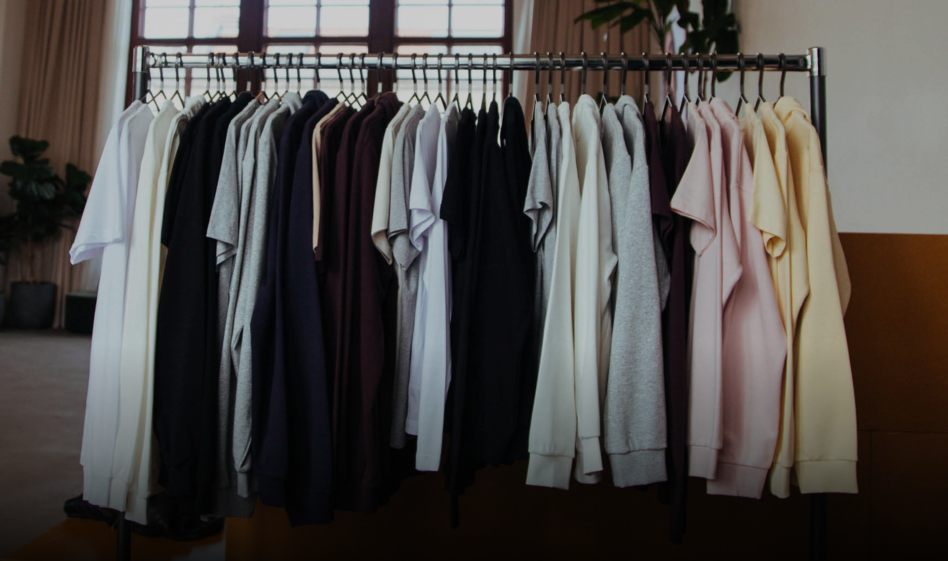 A rack of premium print on demand apparel hanging on hangers