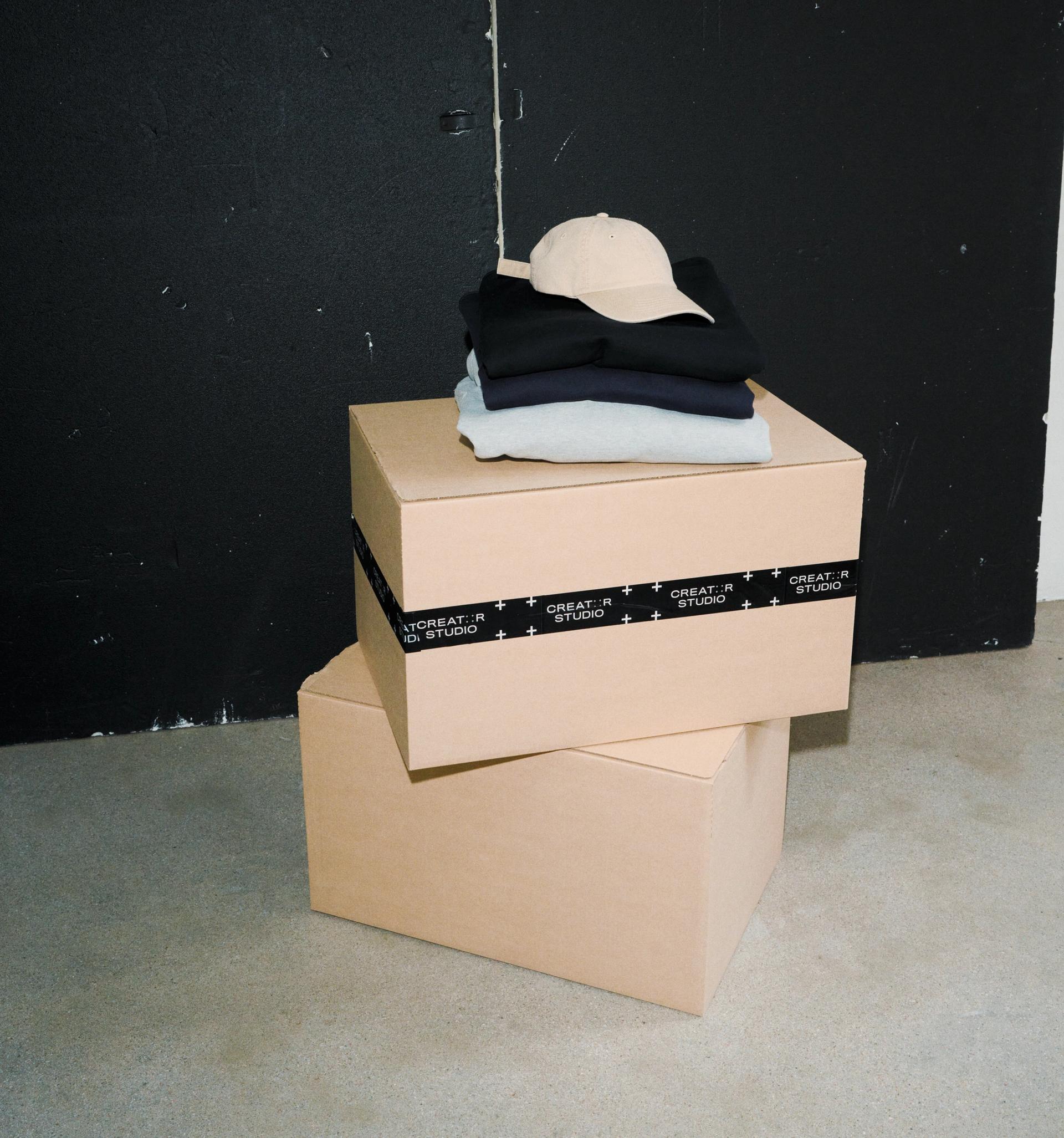 Some Creator Studio merch products on top of two stacked boxes