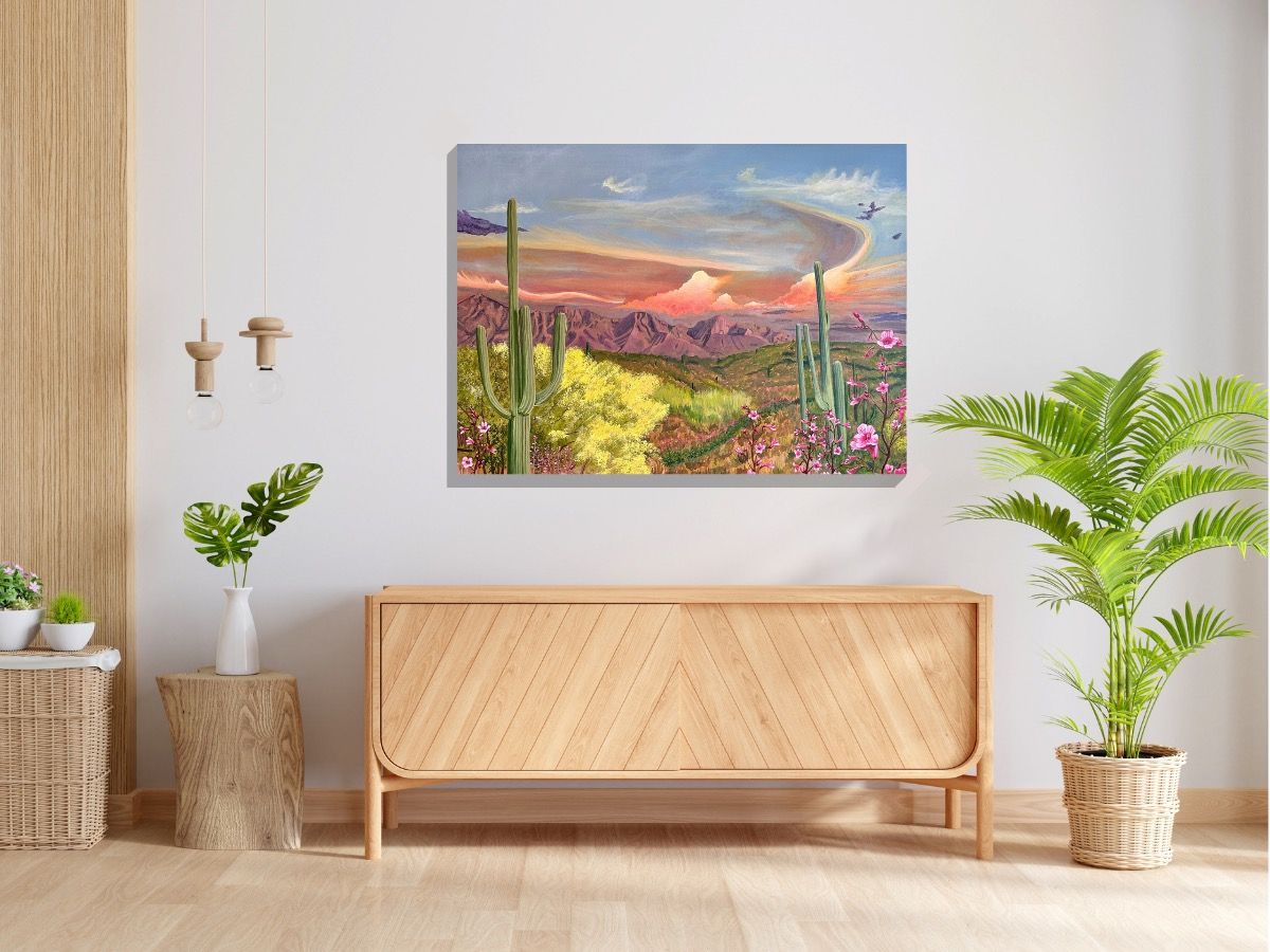 Original Painting. View from Honeybee Canyon in Oro Valley, AZ. Two large saguaro cactus frame the canvas along with pink flowers and a palo verde tree. The Catalina mountains dominate the background in a pink glow. Pink and orange clouds float along the blue sky.
