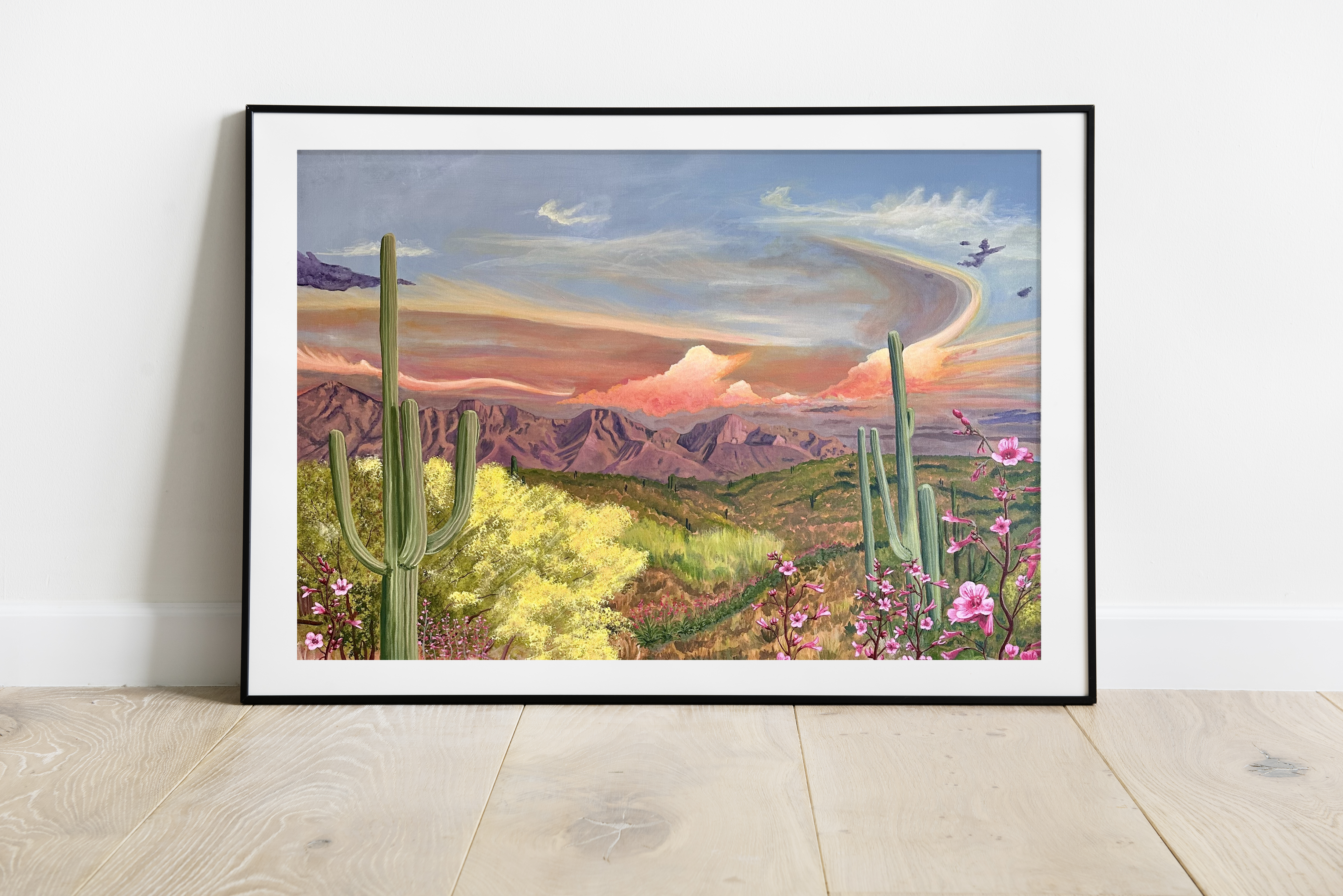 Honeybee Canyon Fine Art Giclèe Print. View from Honeybee Canyon is framed by two large saguaro cacti. Pink flowers line the front. The Catalina Mountains fill the background along with pink and orange clouds in a blue sky.