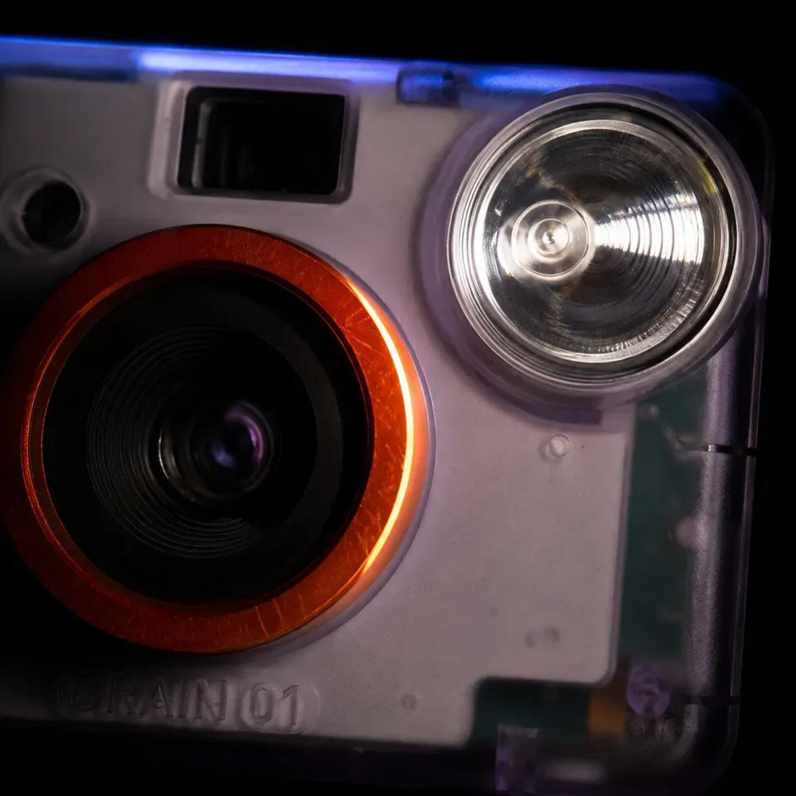 An extreme macro of the GRAIN 01 lens barrel and xenon flash, the orange ring and the fluted reflector filling the frame.