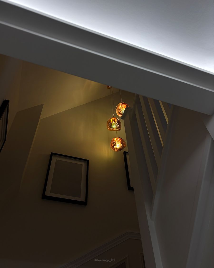 A run of glass pendant lights falling down the panelled stairwell.