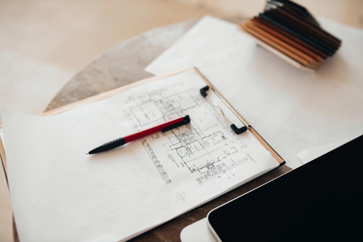Reviewing architectural floor plans and finish samples while scoping a residential refurbishment.