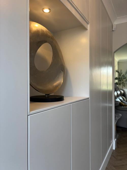 The once-unused recess in the Epsom living room, now flush fitted cupboards with a lit display niche.