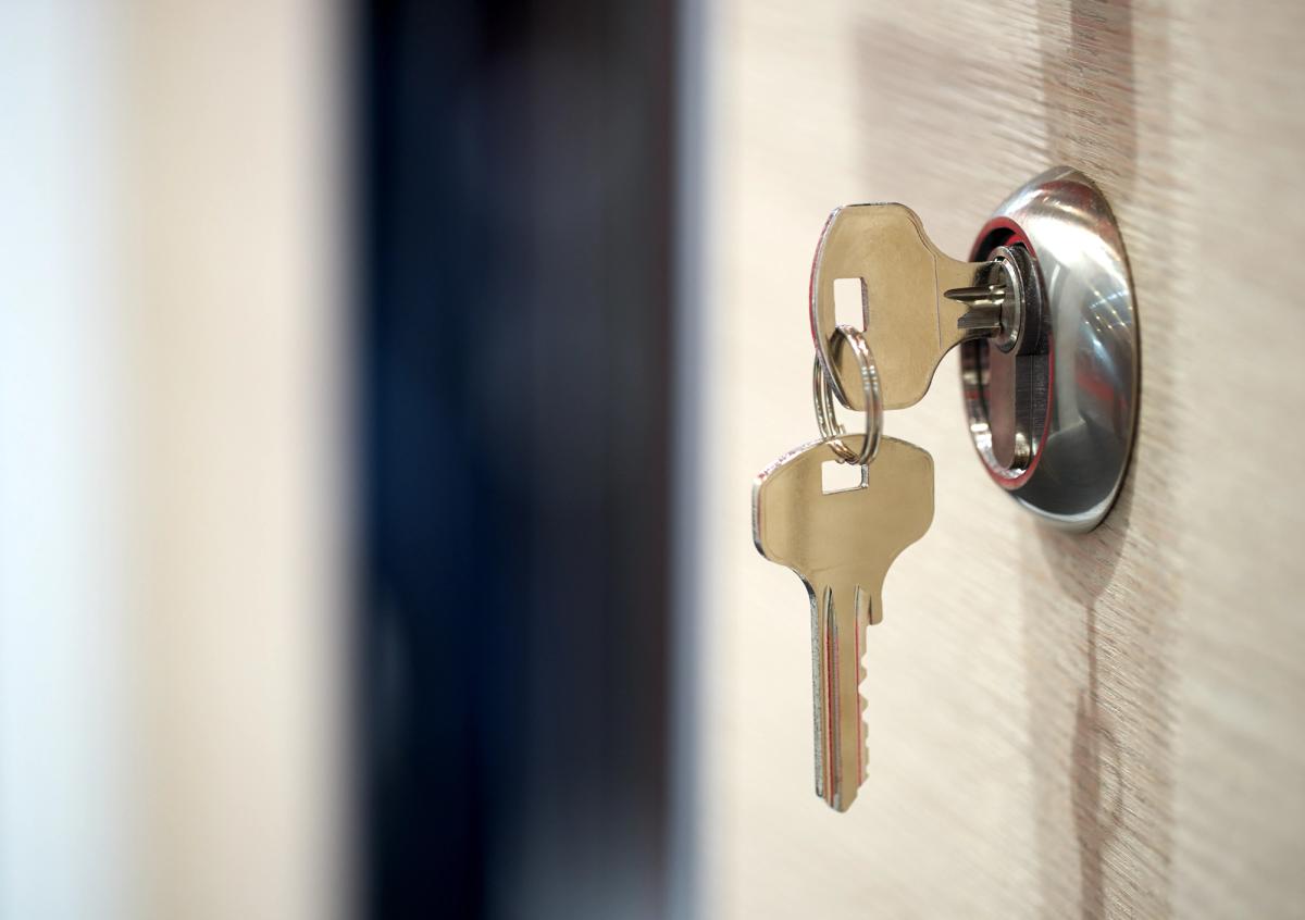 Keys in the door of a finished home, completed to a high standard and ready for handover.