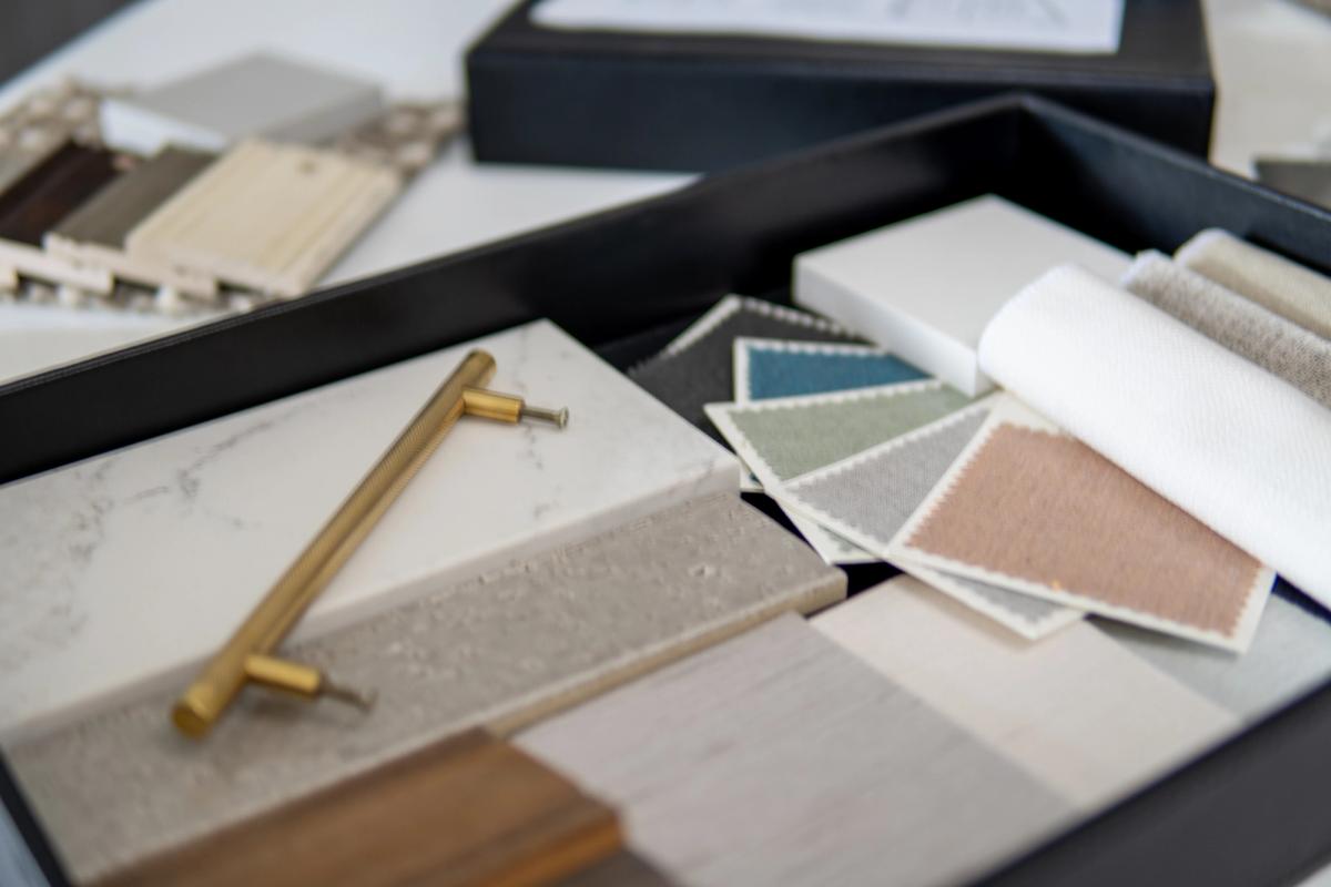 A materials palette of marble, fabric swatches and brass fittings for an interior design scheme.