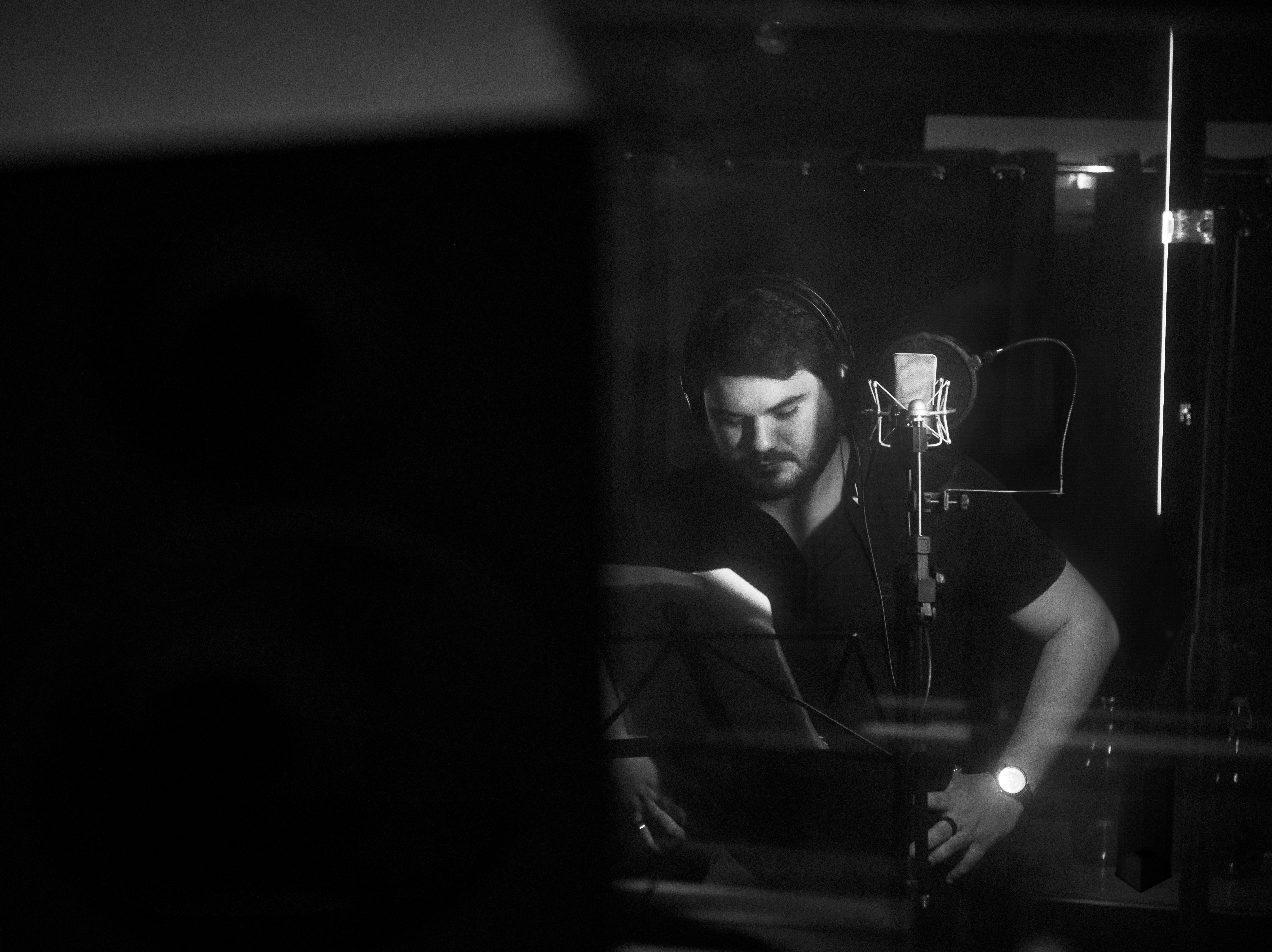 Matheus Granjeiro gravando voz no estúdio, preto e branco