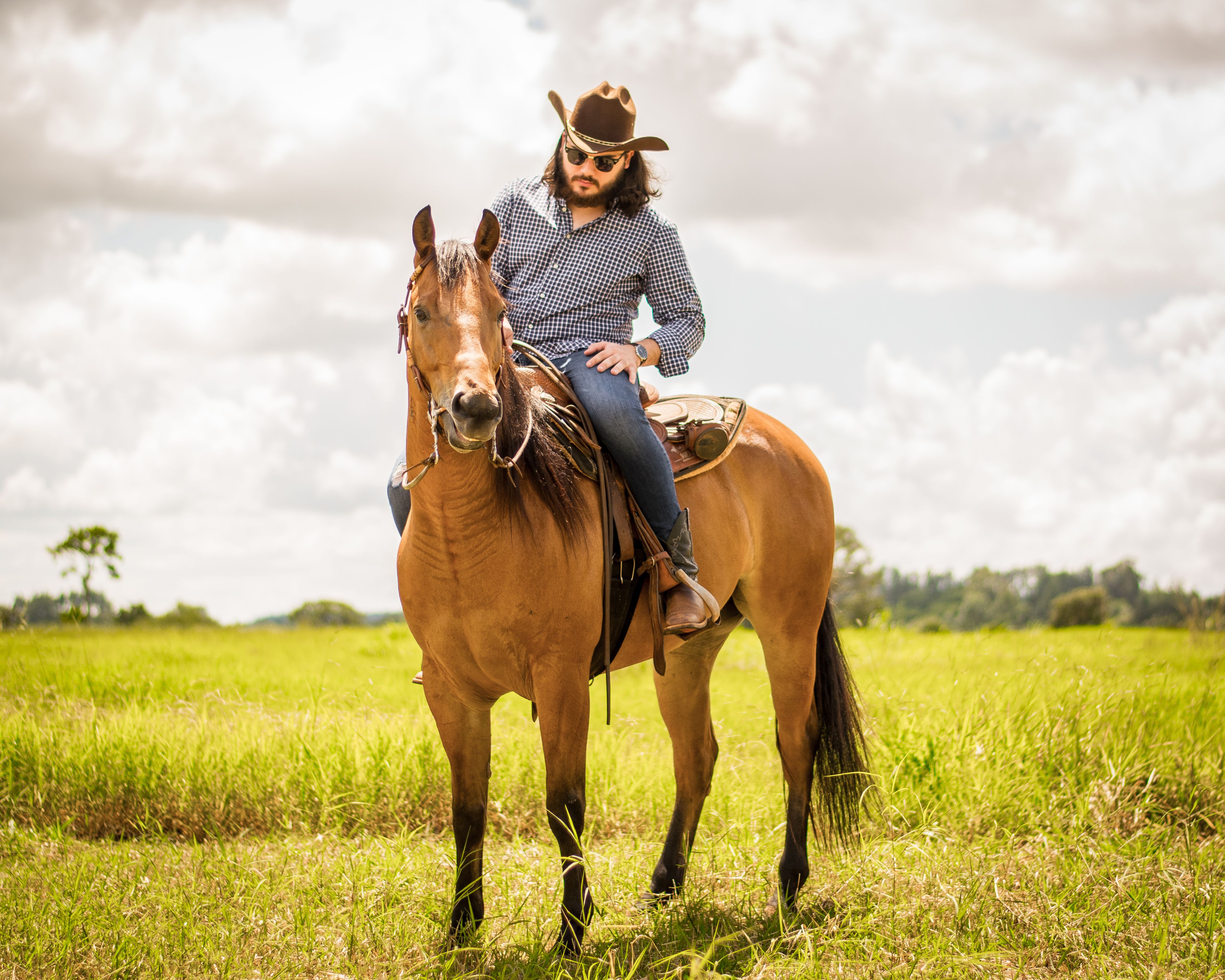Matheus Granjeiro a cavalo em um campo aberto