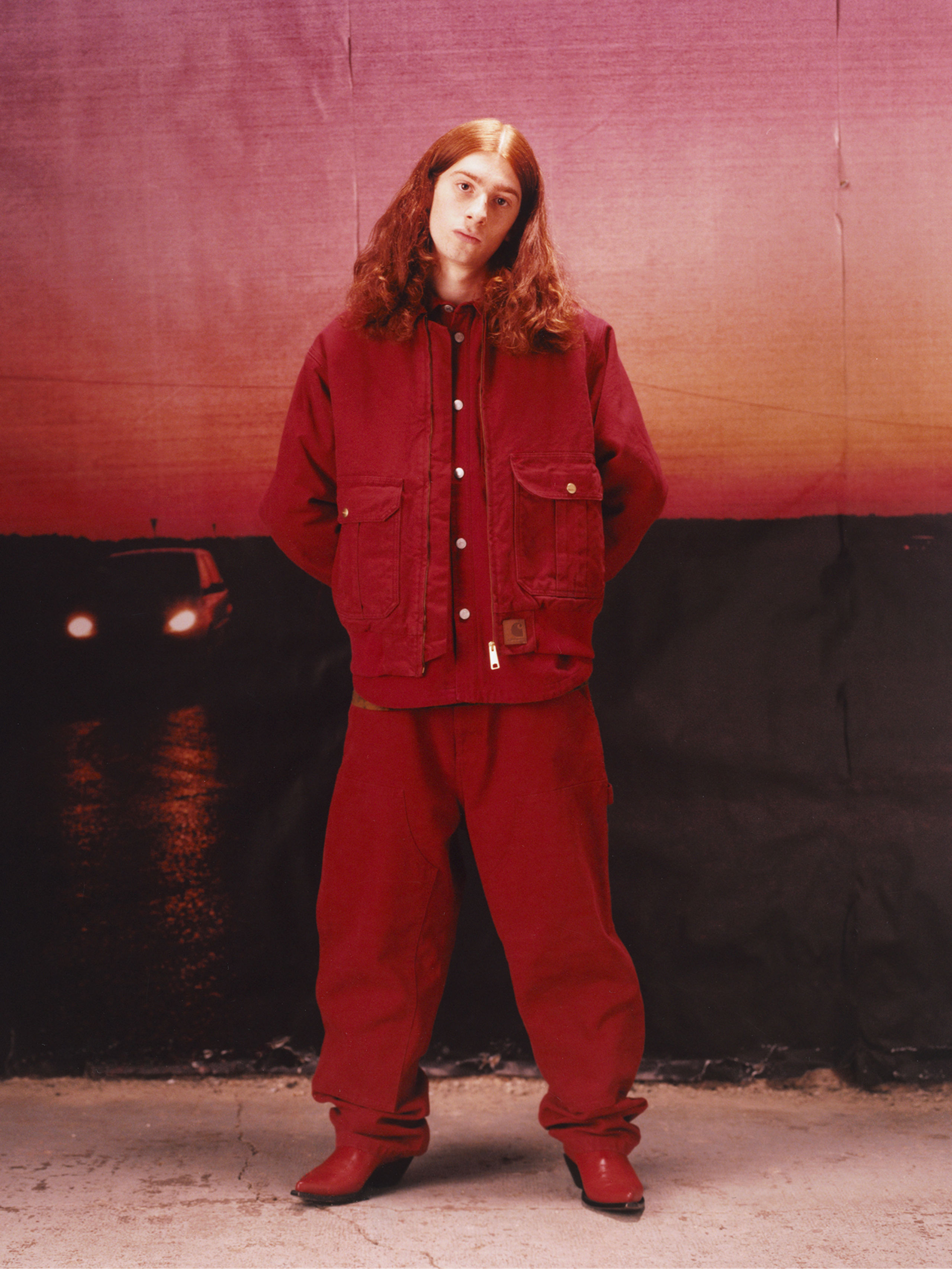 Model wearing an all red outfit in the Carhartt WIP F/W25 Men's Lookbook