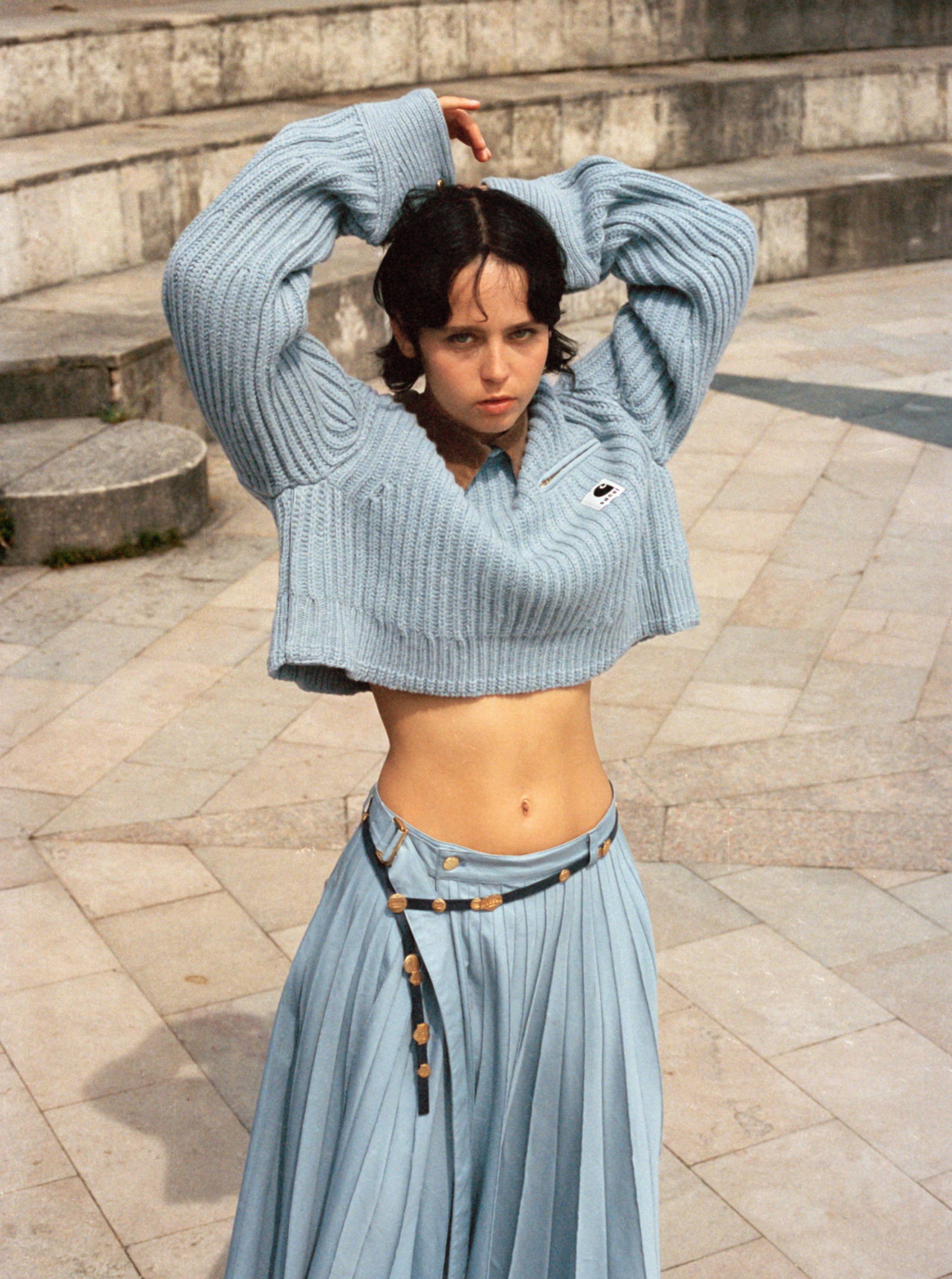 Model wearing sweater from the sacai x Carhartt WIP collection