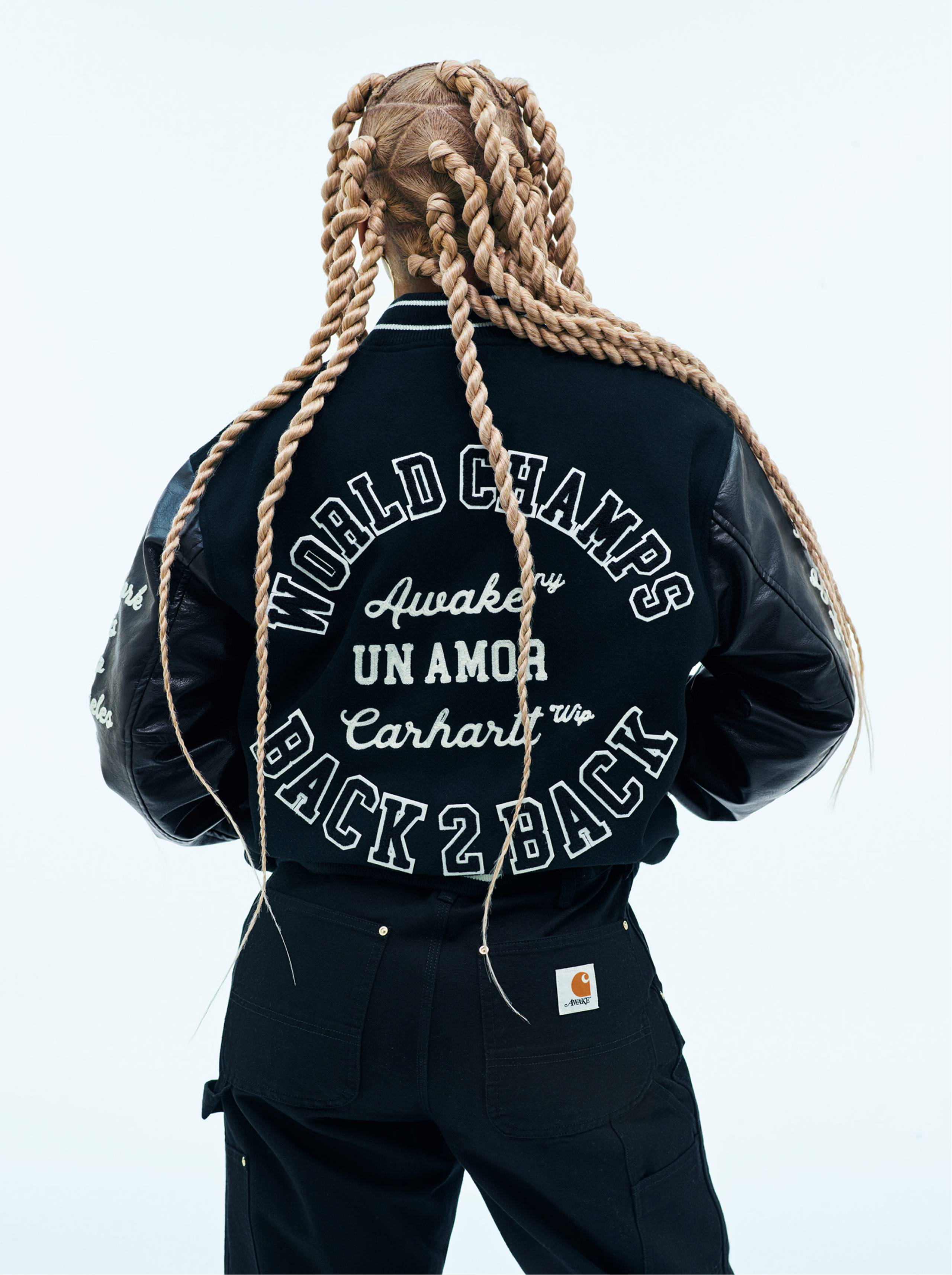 Back shot of model wearing Carhartt WIP x Awake NY Varsity Jacket in Black