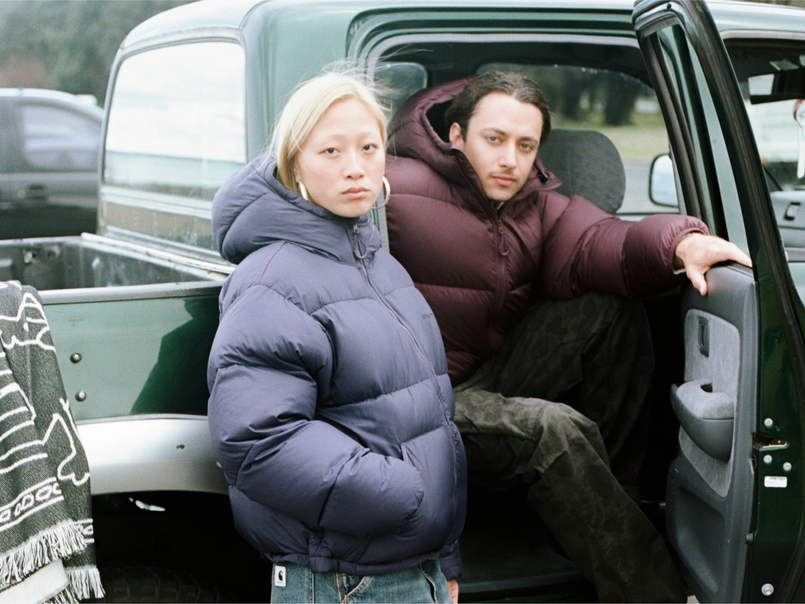 Two people wearing puffer jackets