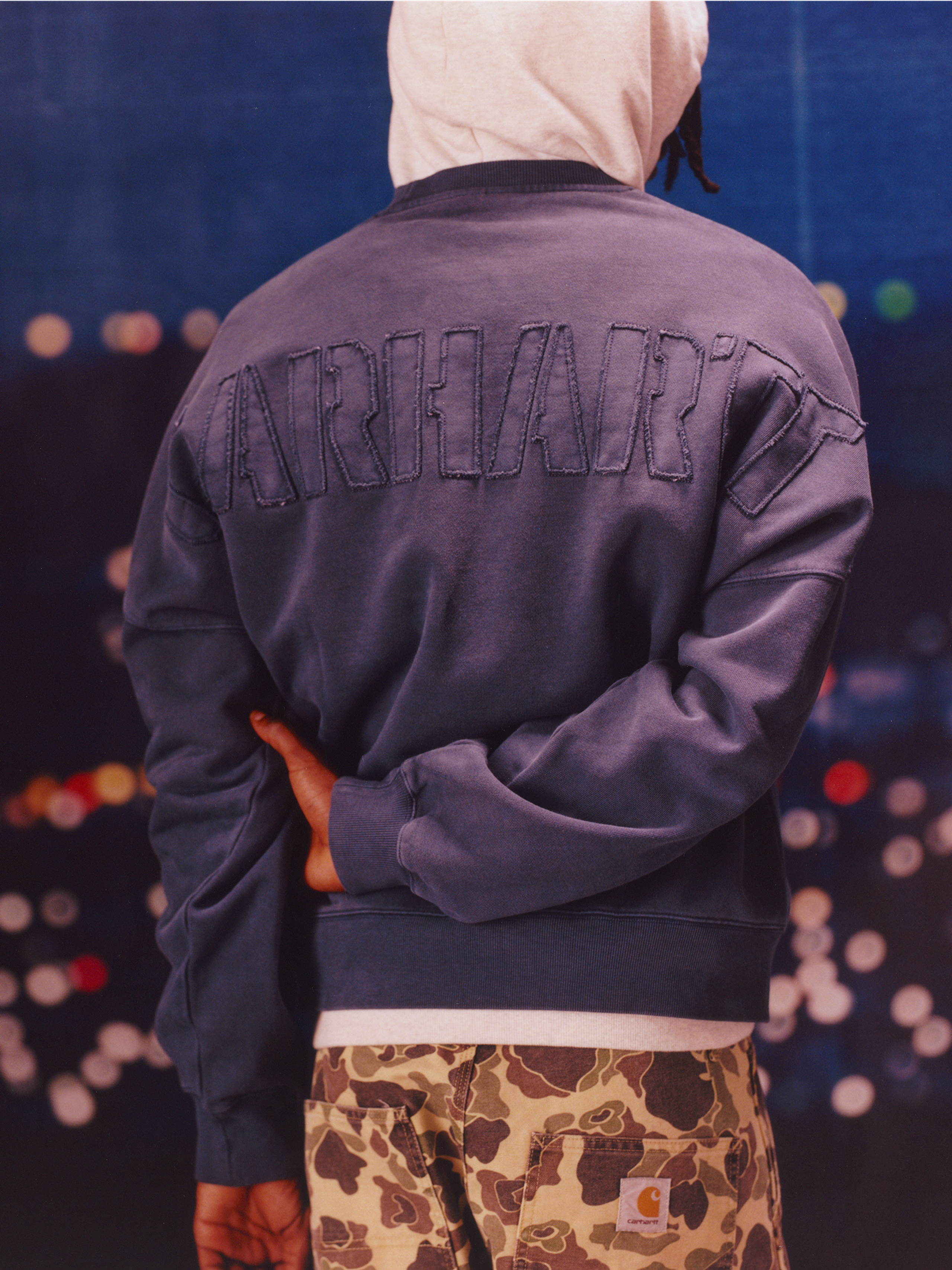 Model wearing an embroidered sweatshirt in the Carhartt WIP F/W25 Men's Lookbook