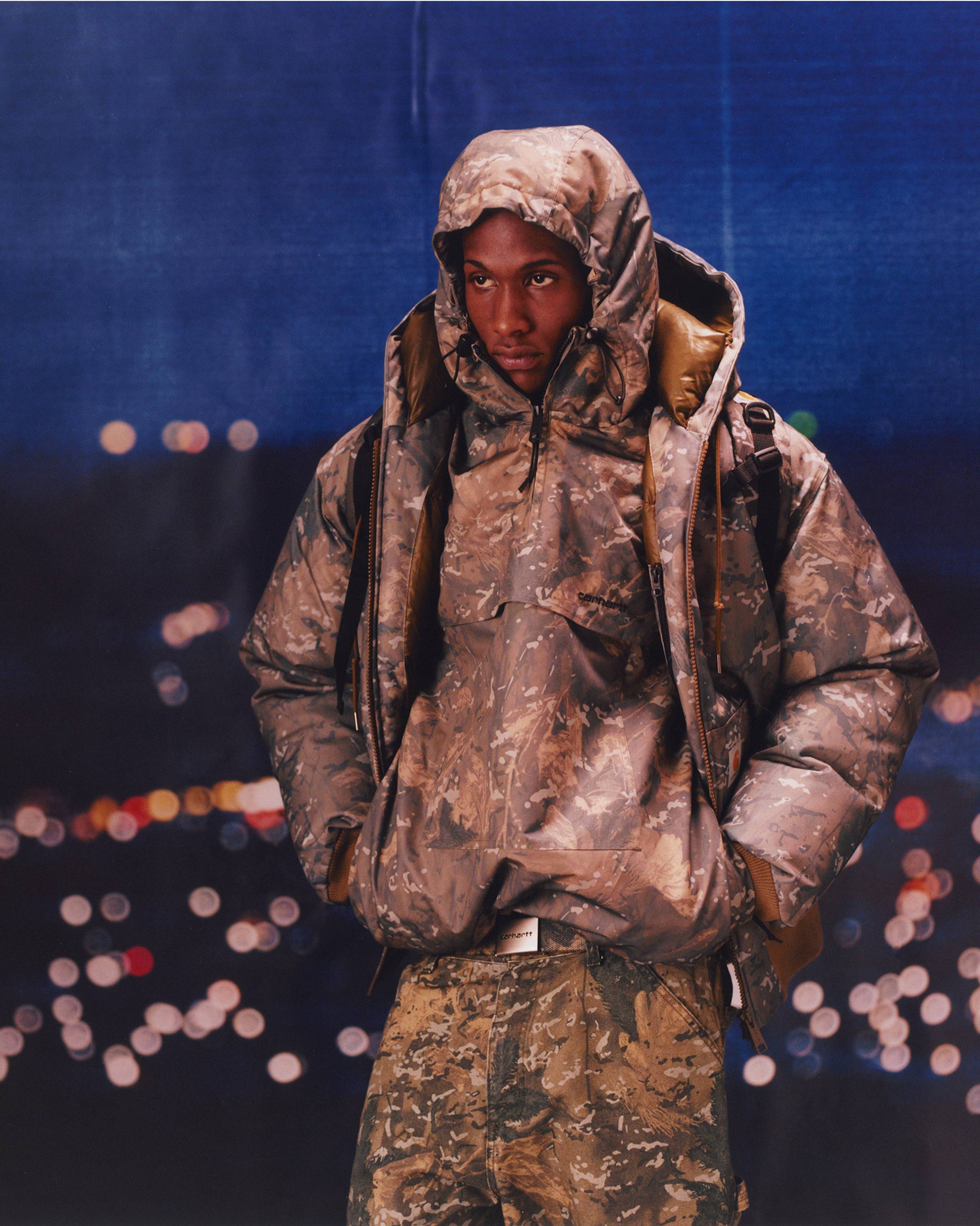 Model wearing items in Camo Combi from the Carhartt WIP F/W25 Collection