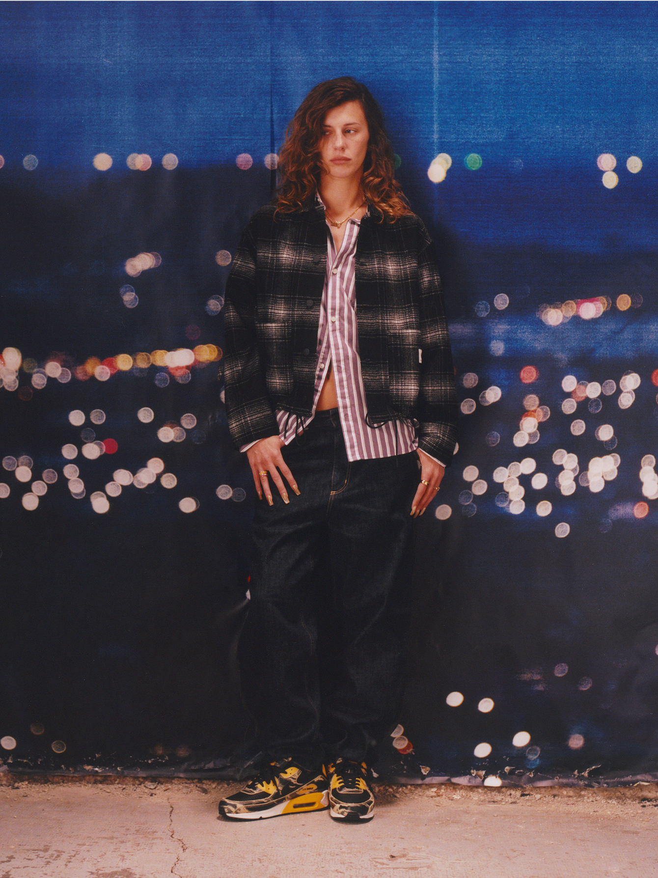 Model wearing a a plaid jacket and denim pants in the Carhartt WIP F/W25 Women's Lookbook