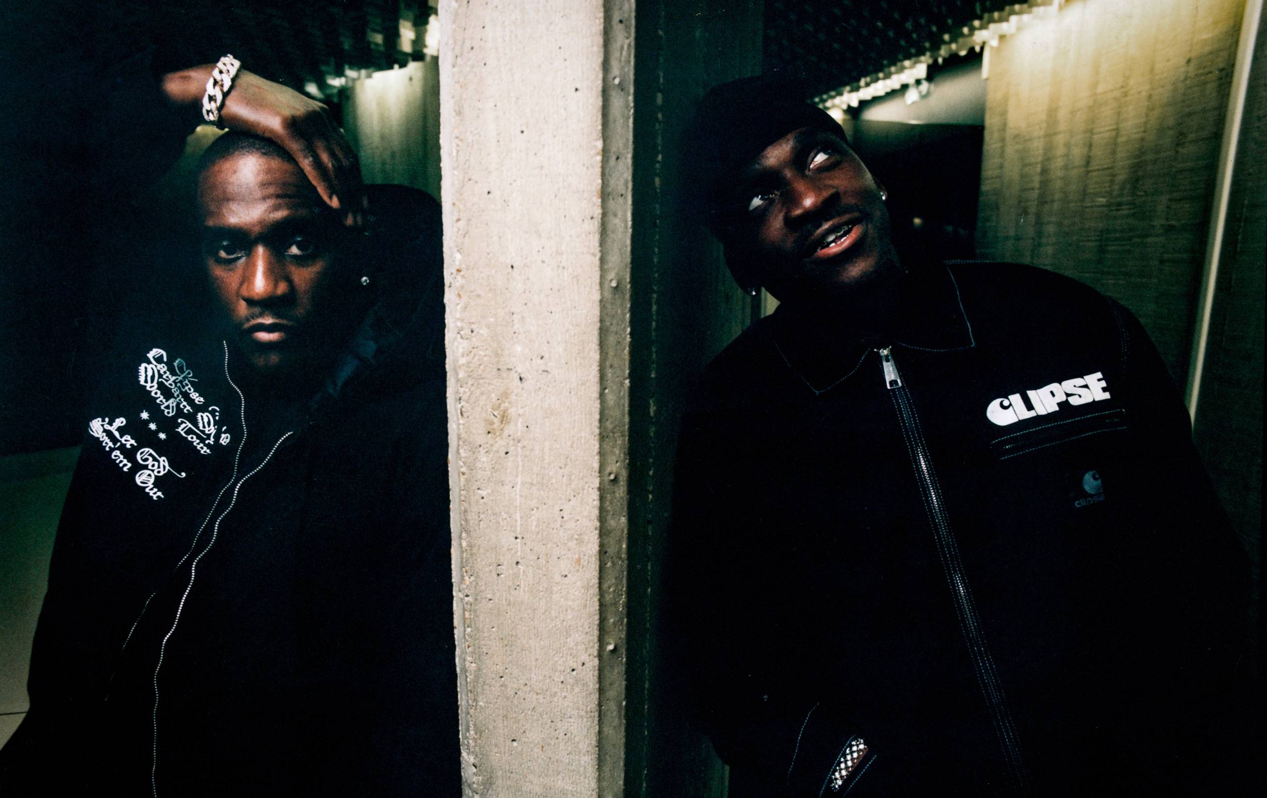 Artist Pusha T and Malice standing against a wall wearing items from the Carhartt WIP x CLIPSE collab