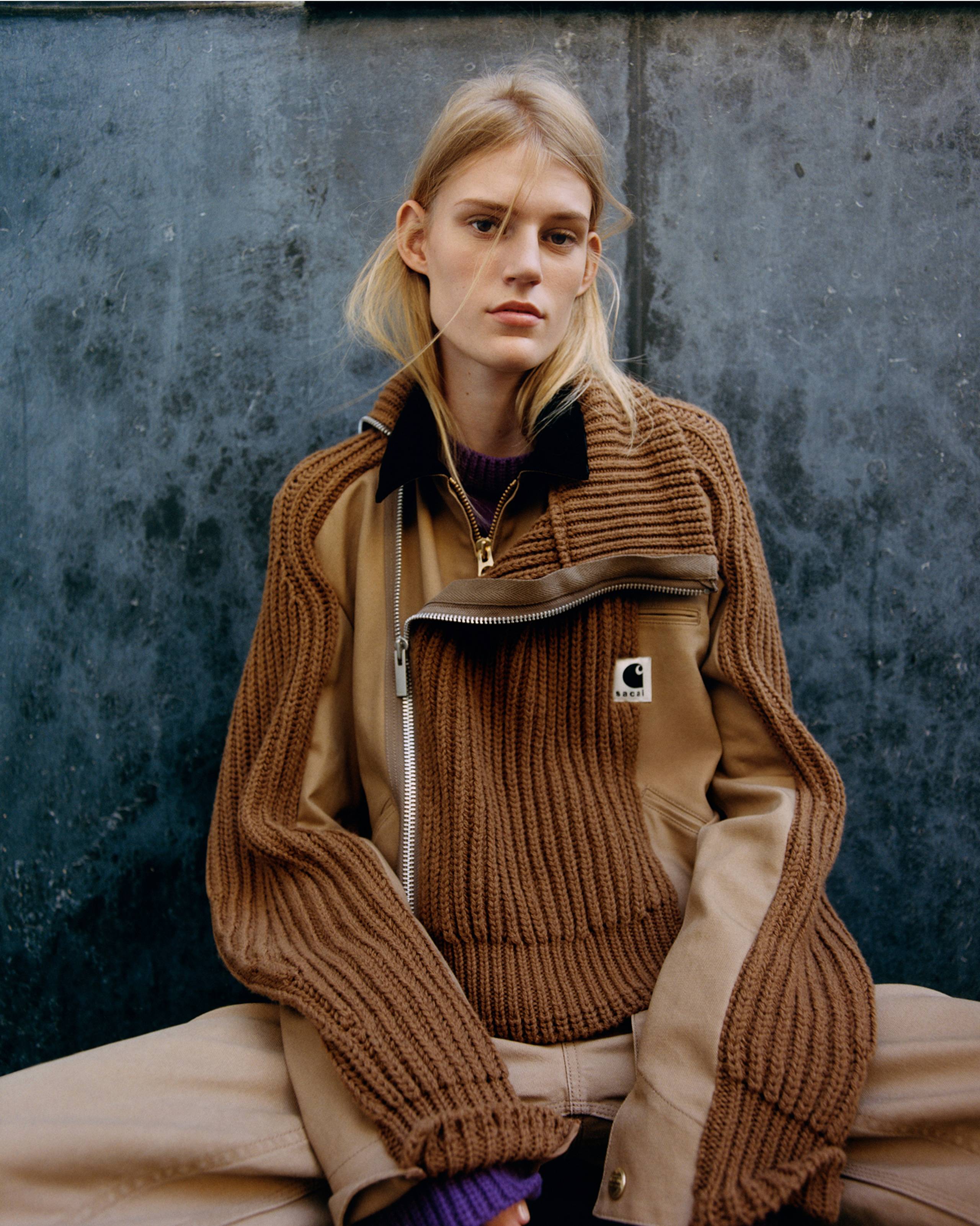 Person wearing a brown sacai x Carhartt WIP zip up sweater jacket