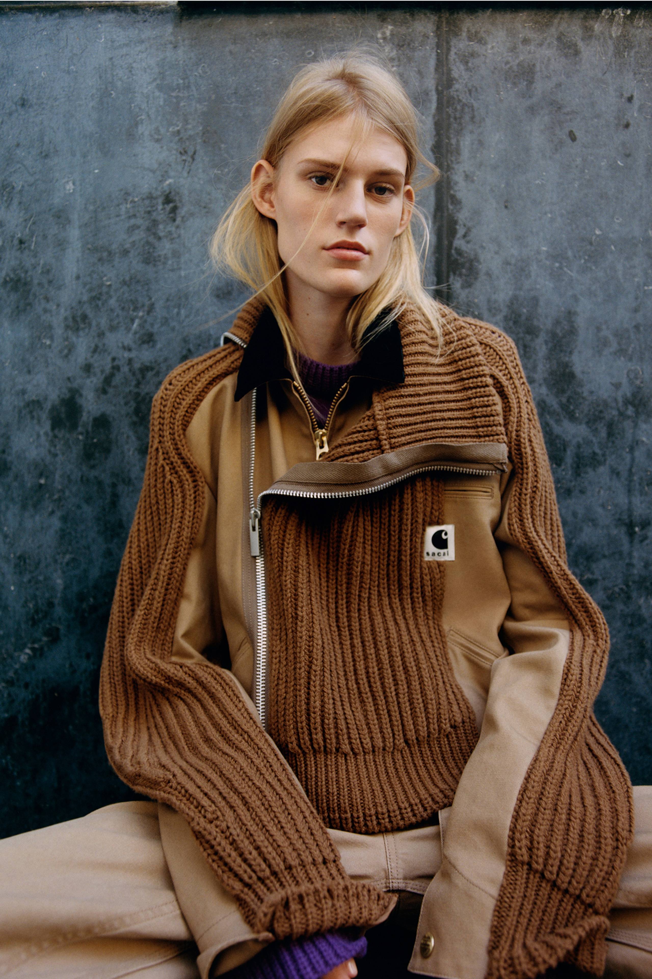 Person wearing a brown sacai x Carhartt WIP zip up sweater jacket