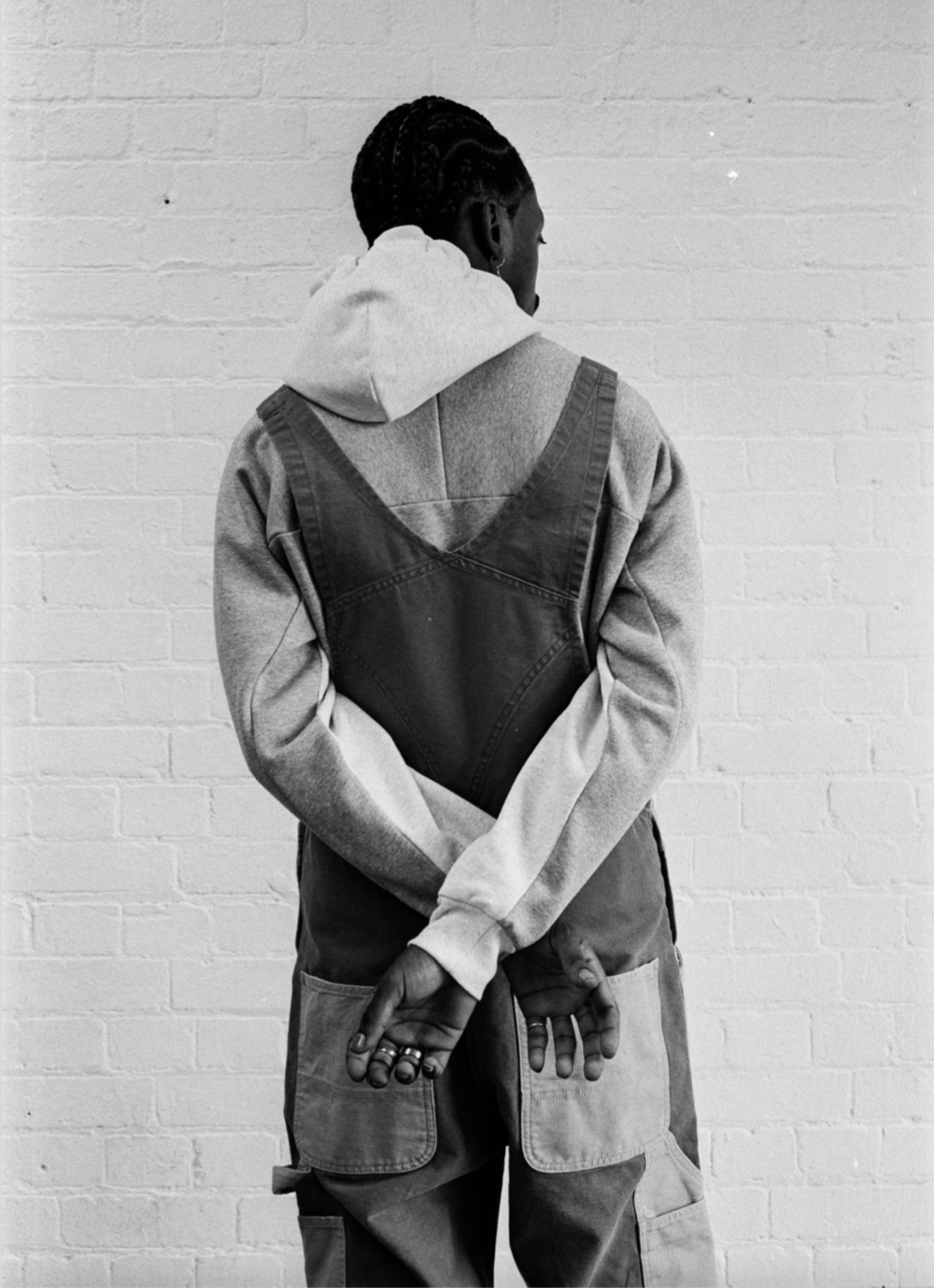 Black and white photo of Model wearing Carhartt WIP Double Knee Bib Overall in Two Tone Dusty Hamilton Brown