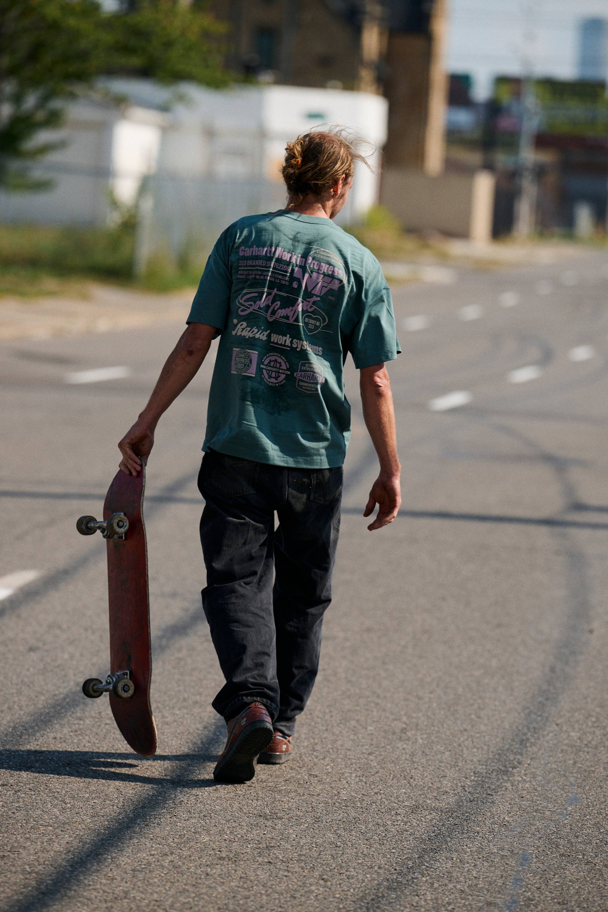 Skater holding a skateboard wearing a Networks T-Shirt