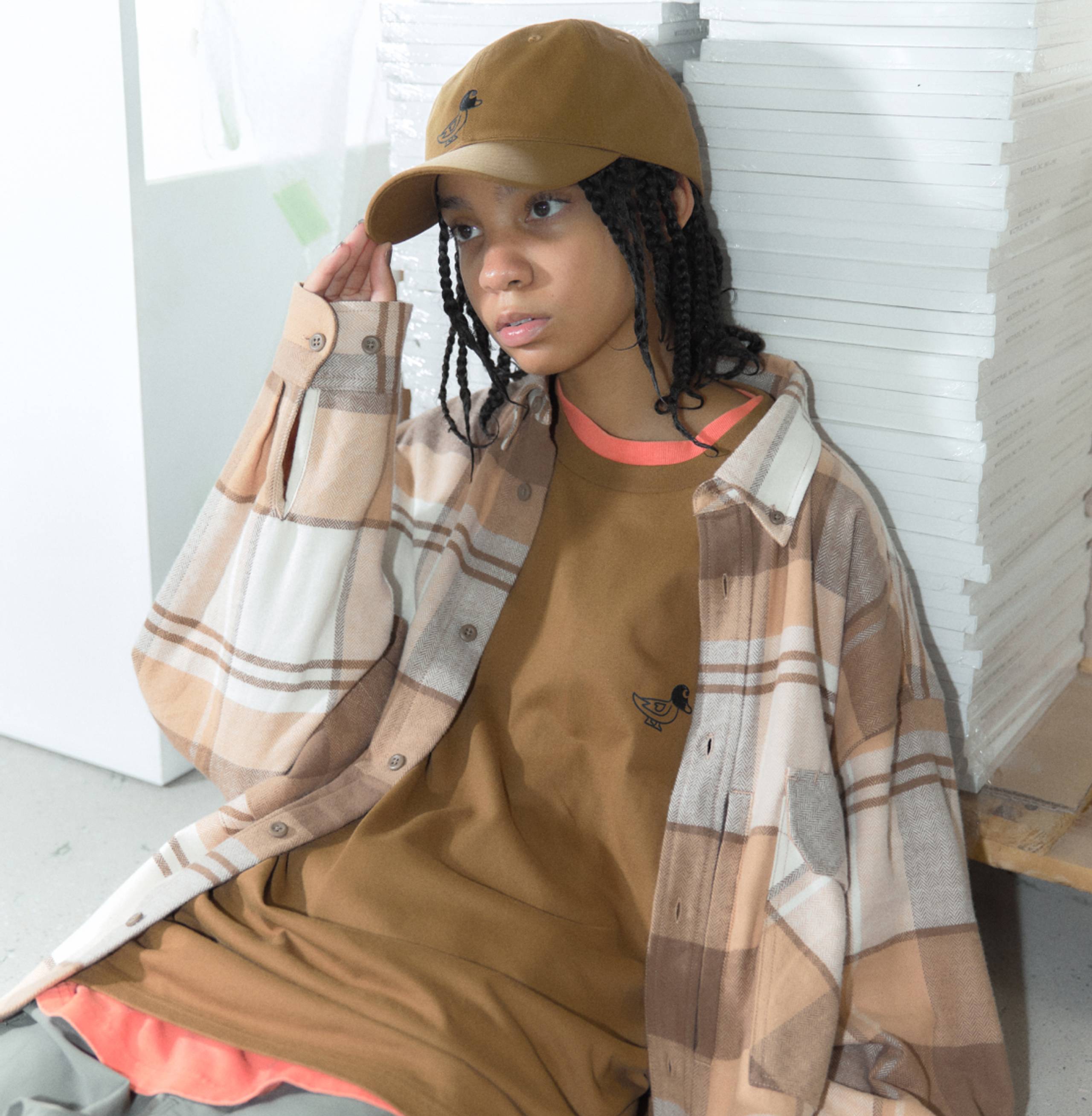 Model wearing Carhartt WIP x INVINCIBLE Work Shirt Max in brown plaid print