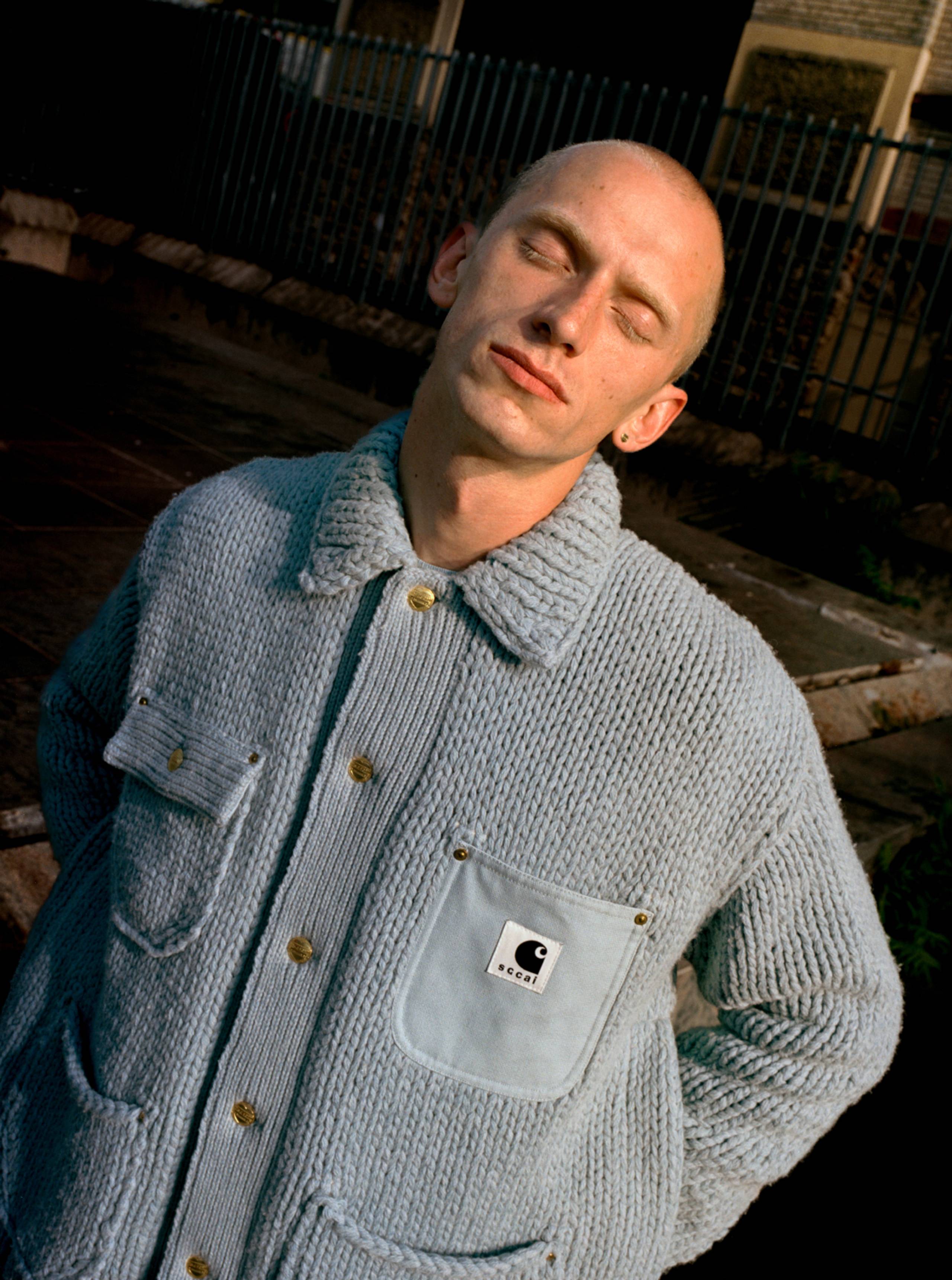 Model wearing sweater from the sacai x Carhartt WIP collection