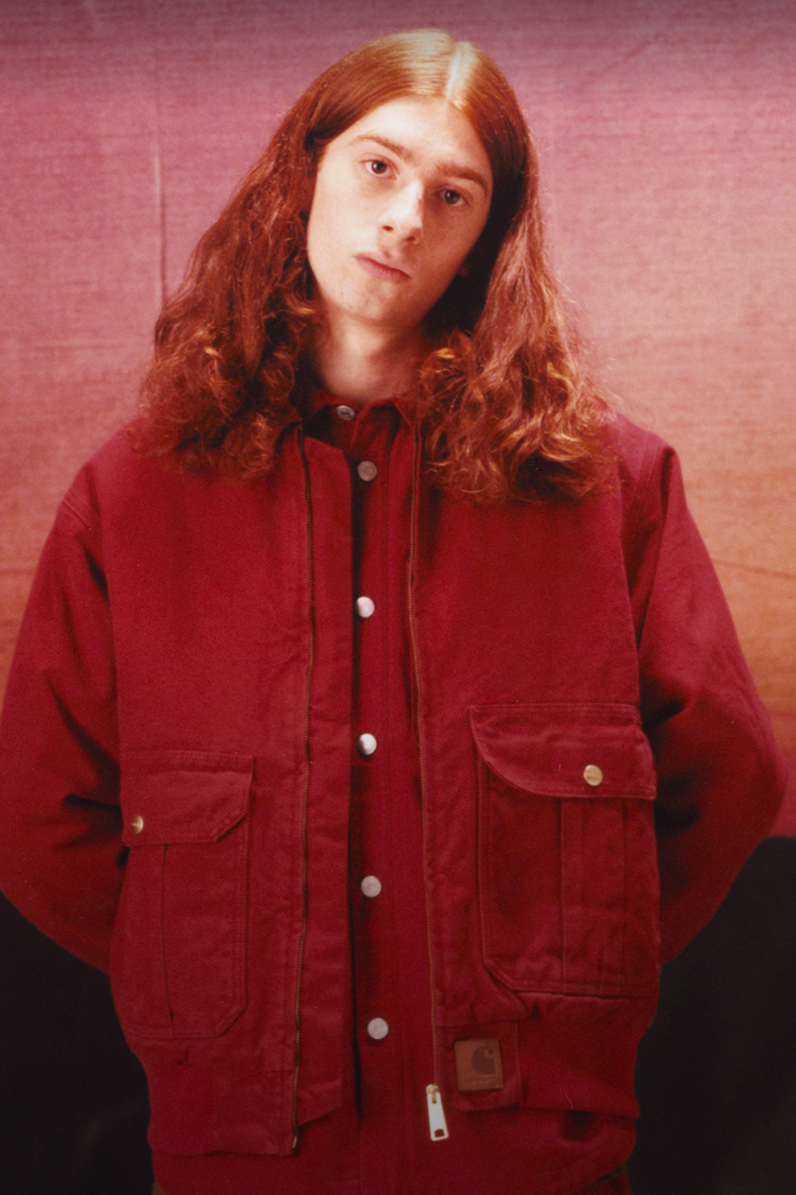Model wearing an all red outfit in the Carhartt WIP F/W25 Men's Lookbook
