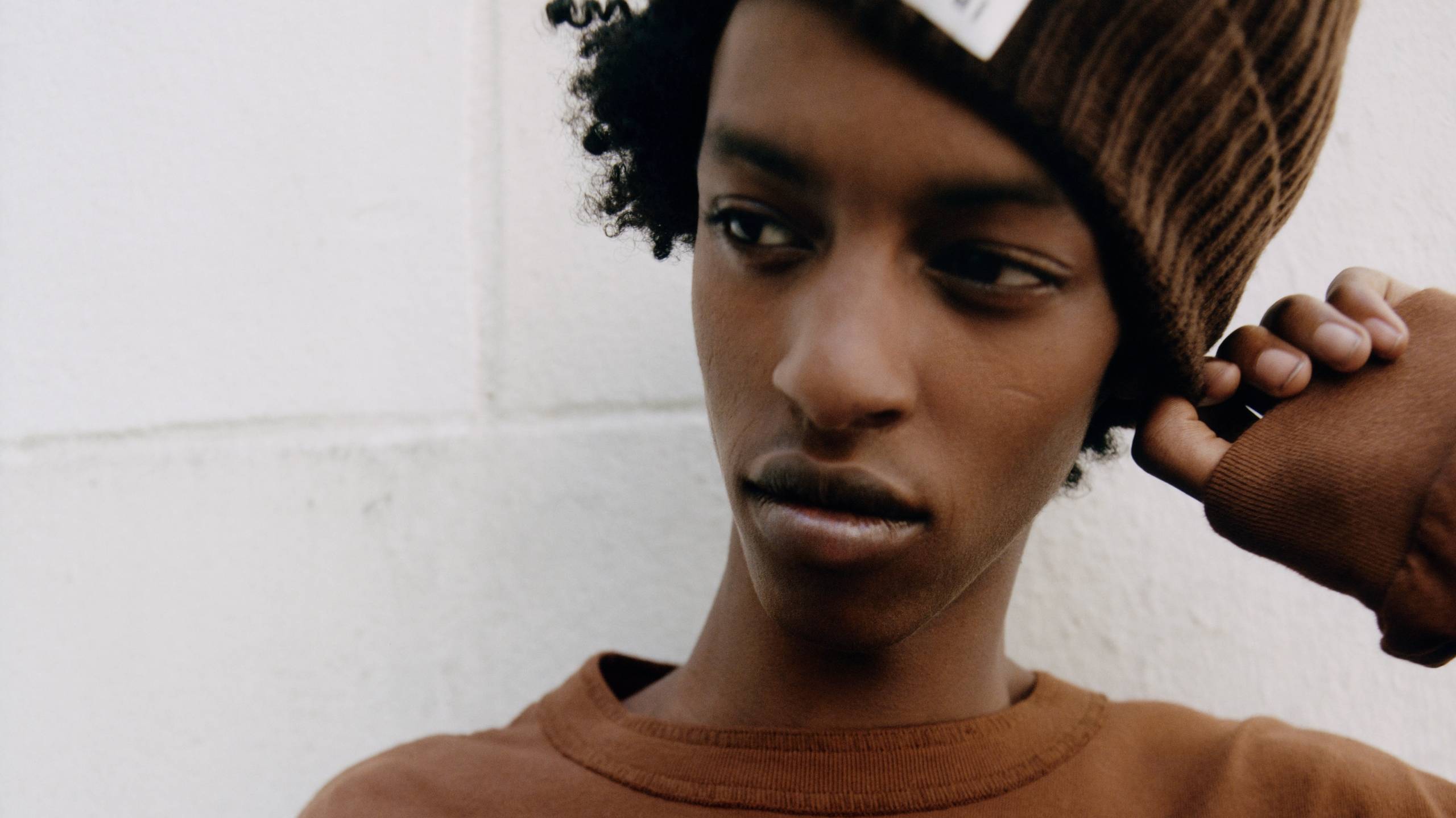Model wearing a sacai x carhartt WIP beanie and longsleeve shirt