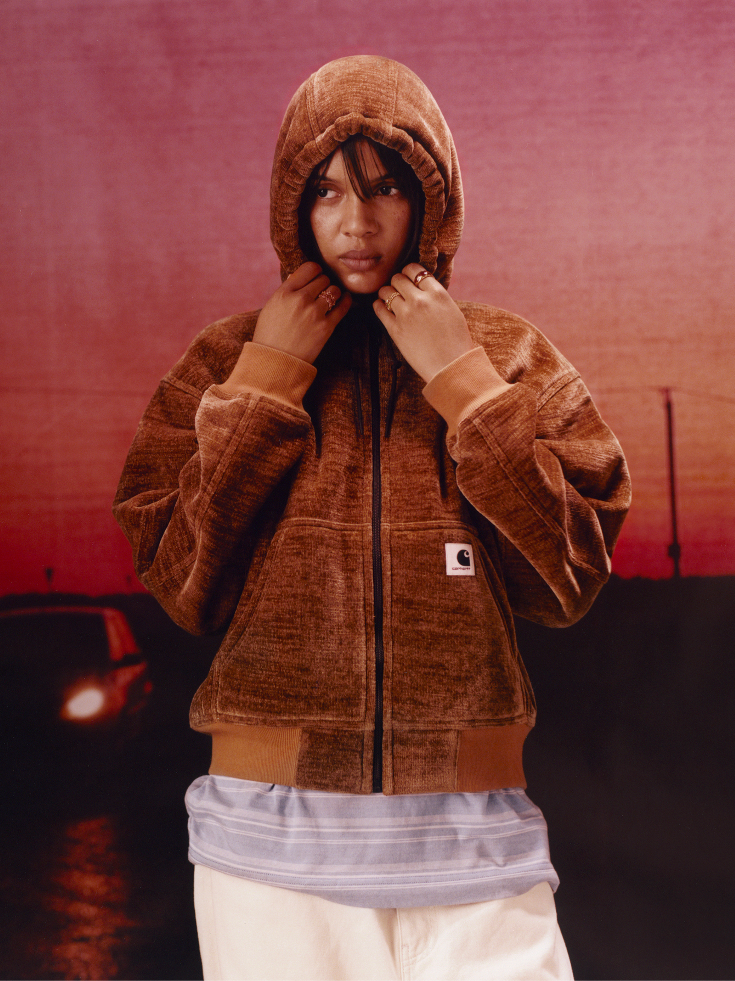 Model wearing a brown hooded active sweatshirt in the Carhartt WIP F/W25 Women's Lookbook