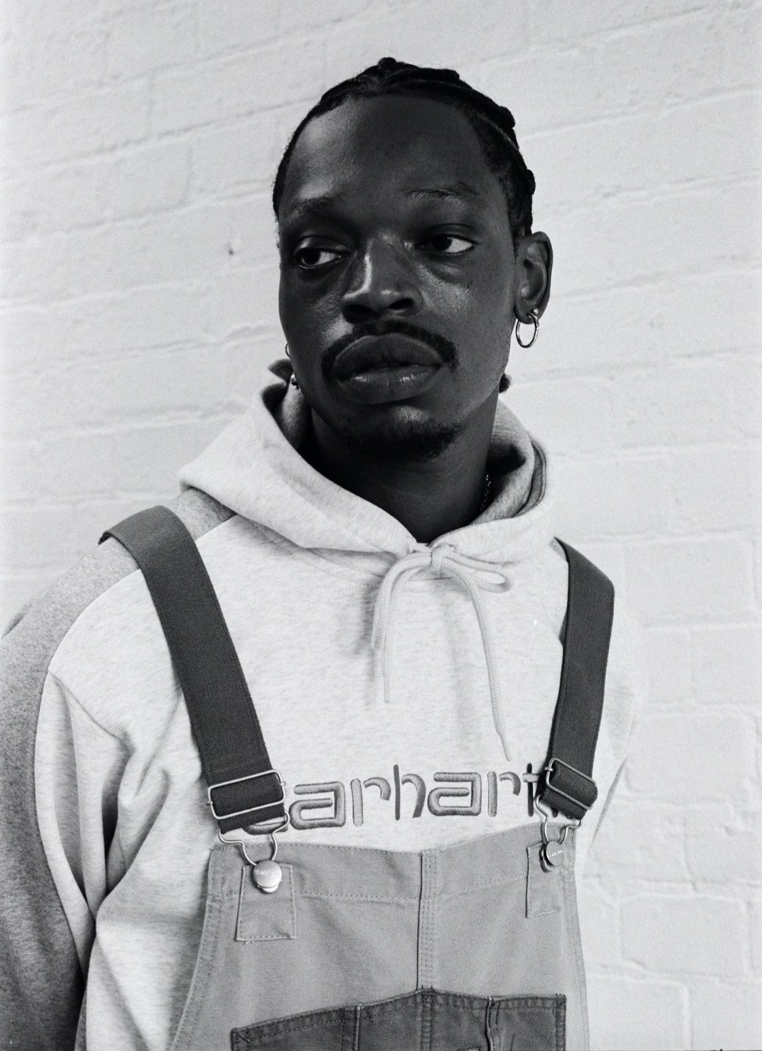 Black and white photo of Model wearing Carhartt WIP Double Knee Bib Overall in Two Tone Dusty Hamilton Brown