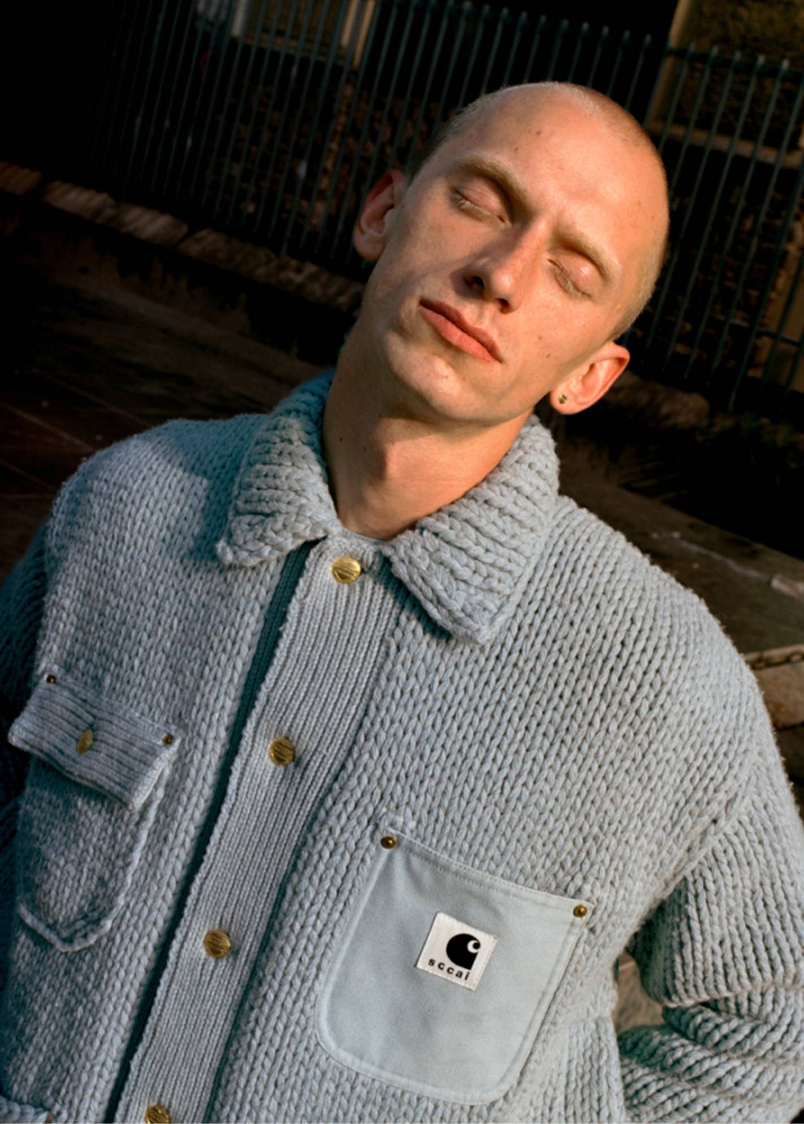 Model wearing sweater from the sacai x Carhartt WIP collection