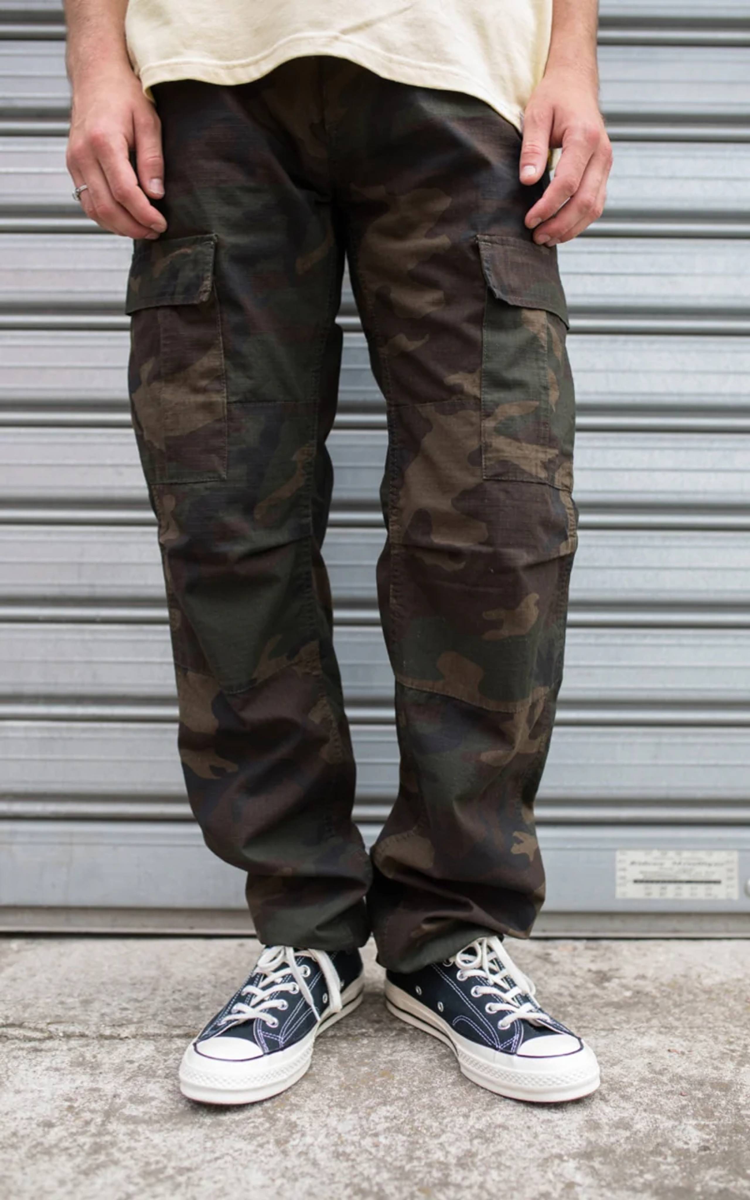 Model wearing dark camo Carhartt WIP cargo pants
