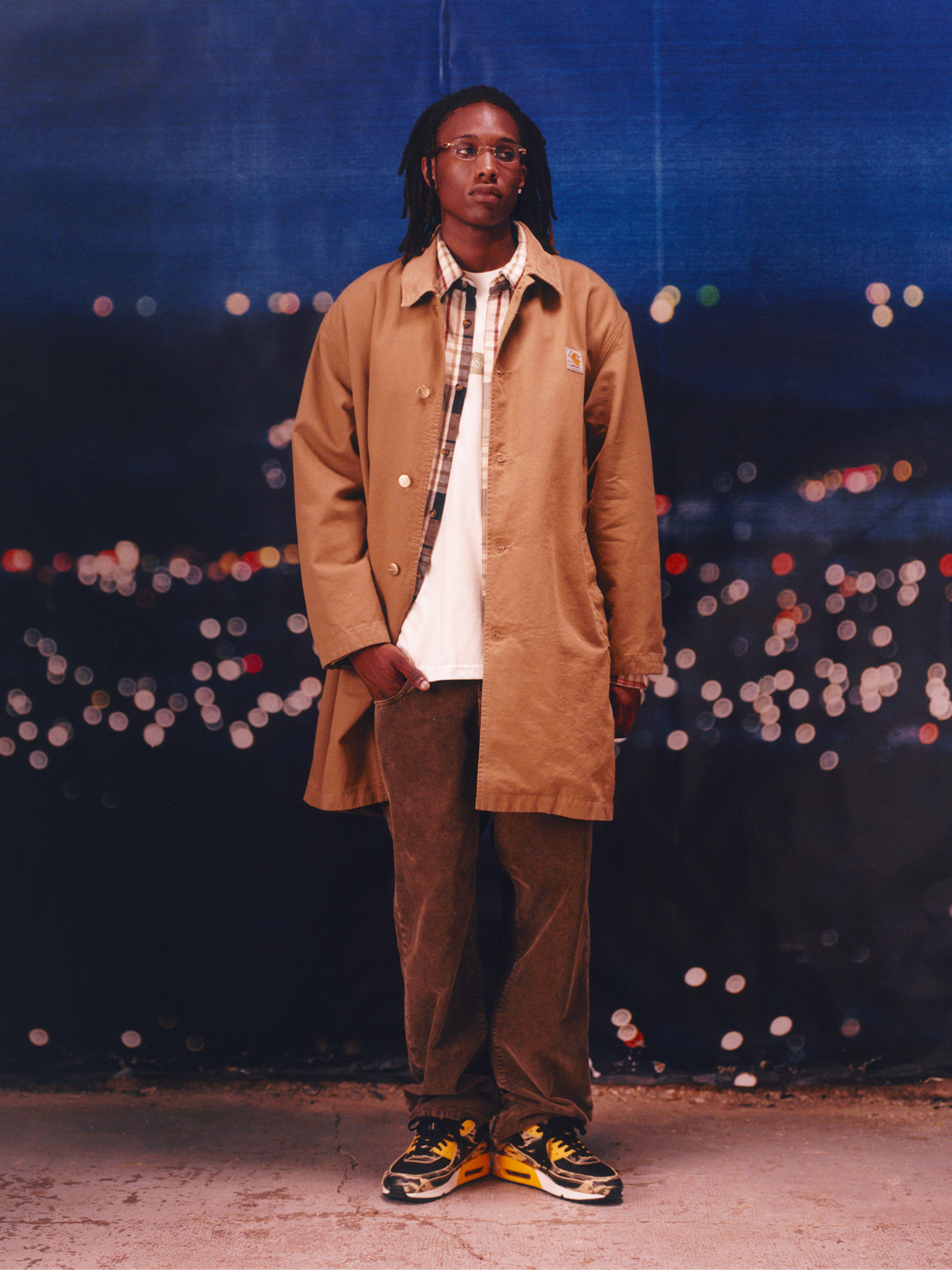 Model wearing a tan Webster long coat in the Carhartt WIP F/W25 Men's Lookbook