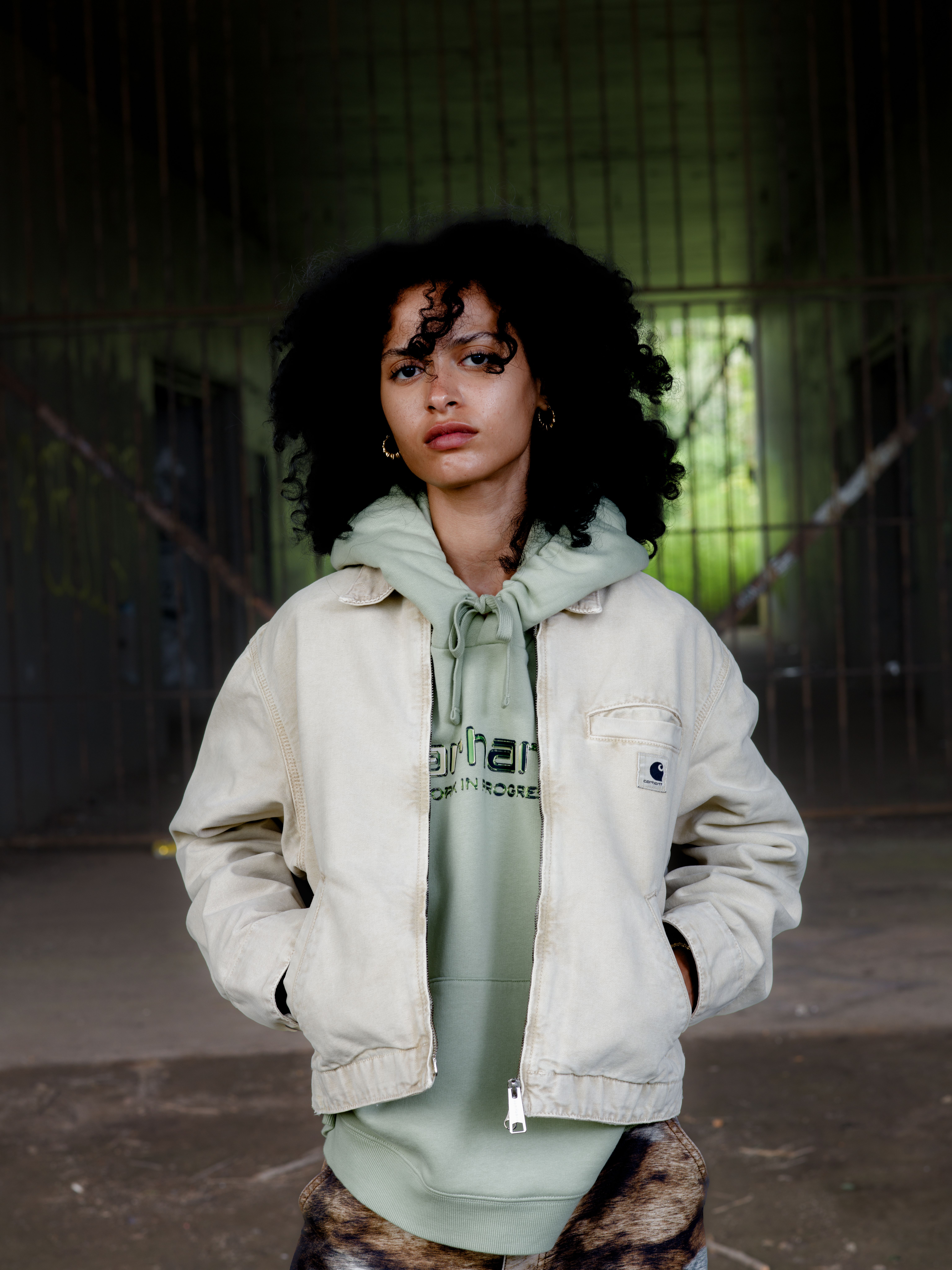 Model wearing a Women's Emery Jacket in Dusty Hamilton Brown and a Women’s Hooded Solar Chrome Sweatshirt in Pale Olive