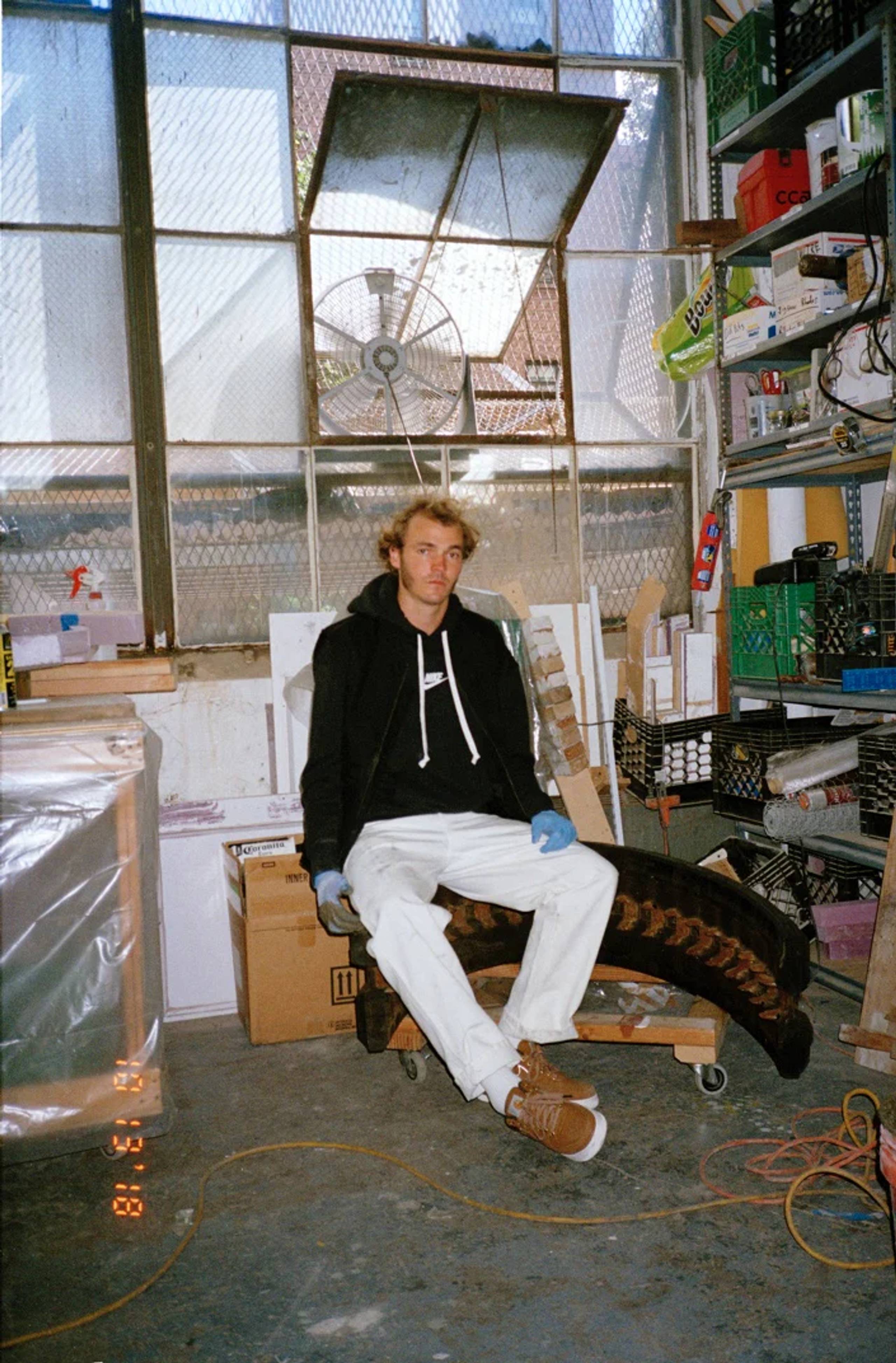 model wearing brown Carhartt WIP x Nike Air Force 1 Low sneakers in a warehouse