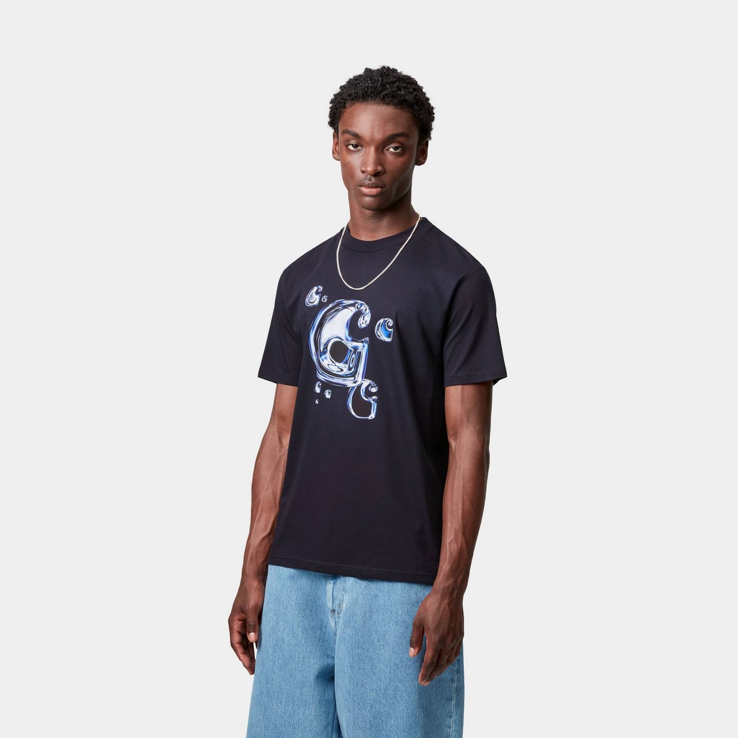 Model wearing Carhartt WIP solar chrome graphic t-shirt and blue jeans